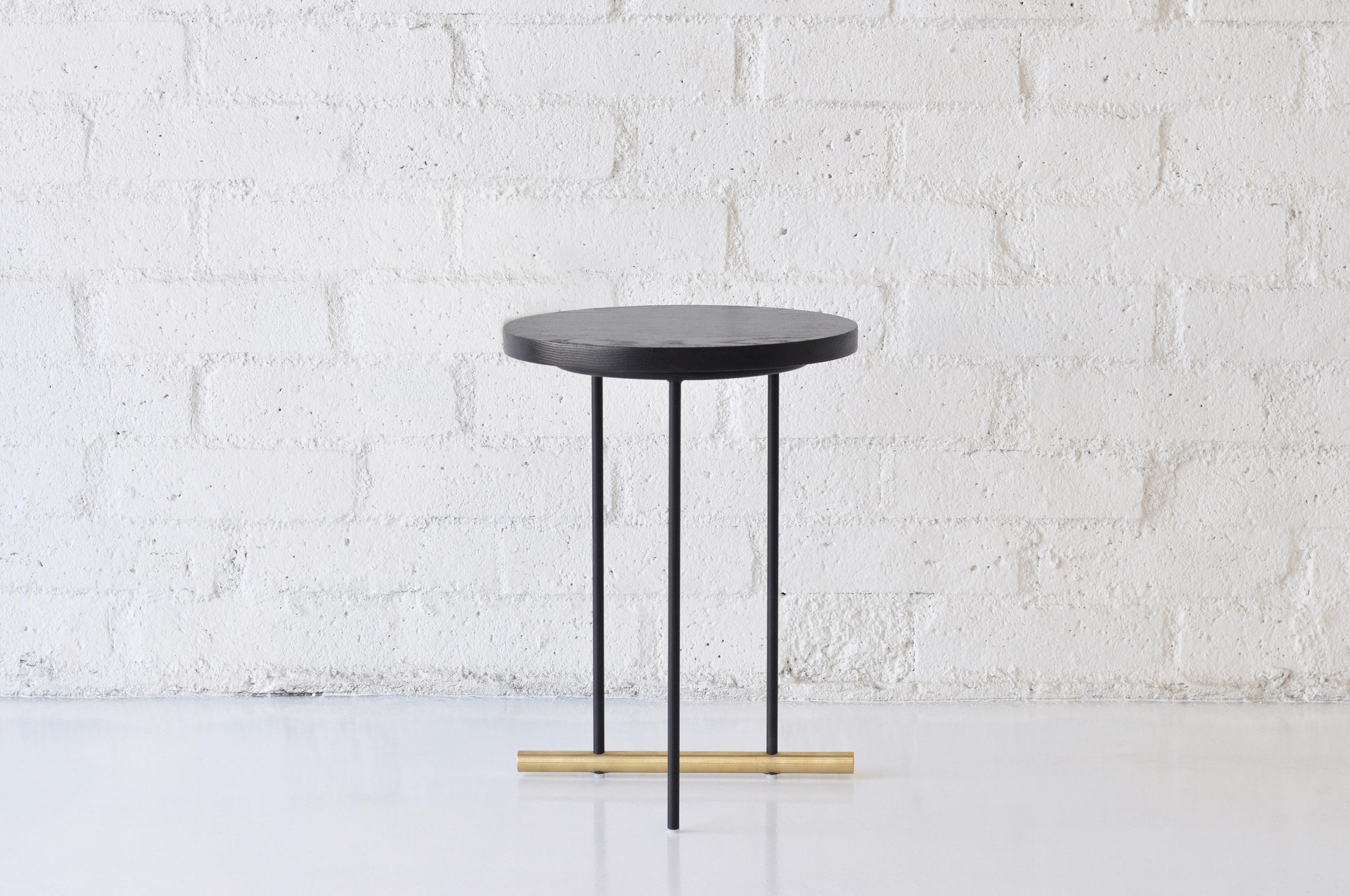 Icon Small Ebonized Oak Side Table by Phase Design
Dimensions: Ø 38,1 x H 51.5 cm. 
Materials: Ebonized oak, powder-coated metal and brushed brass.

Solid steel and brass with glass, marble, or solid wooden tops. Steel bar available in a flat black