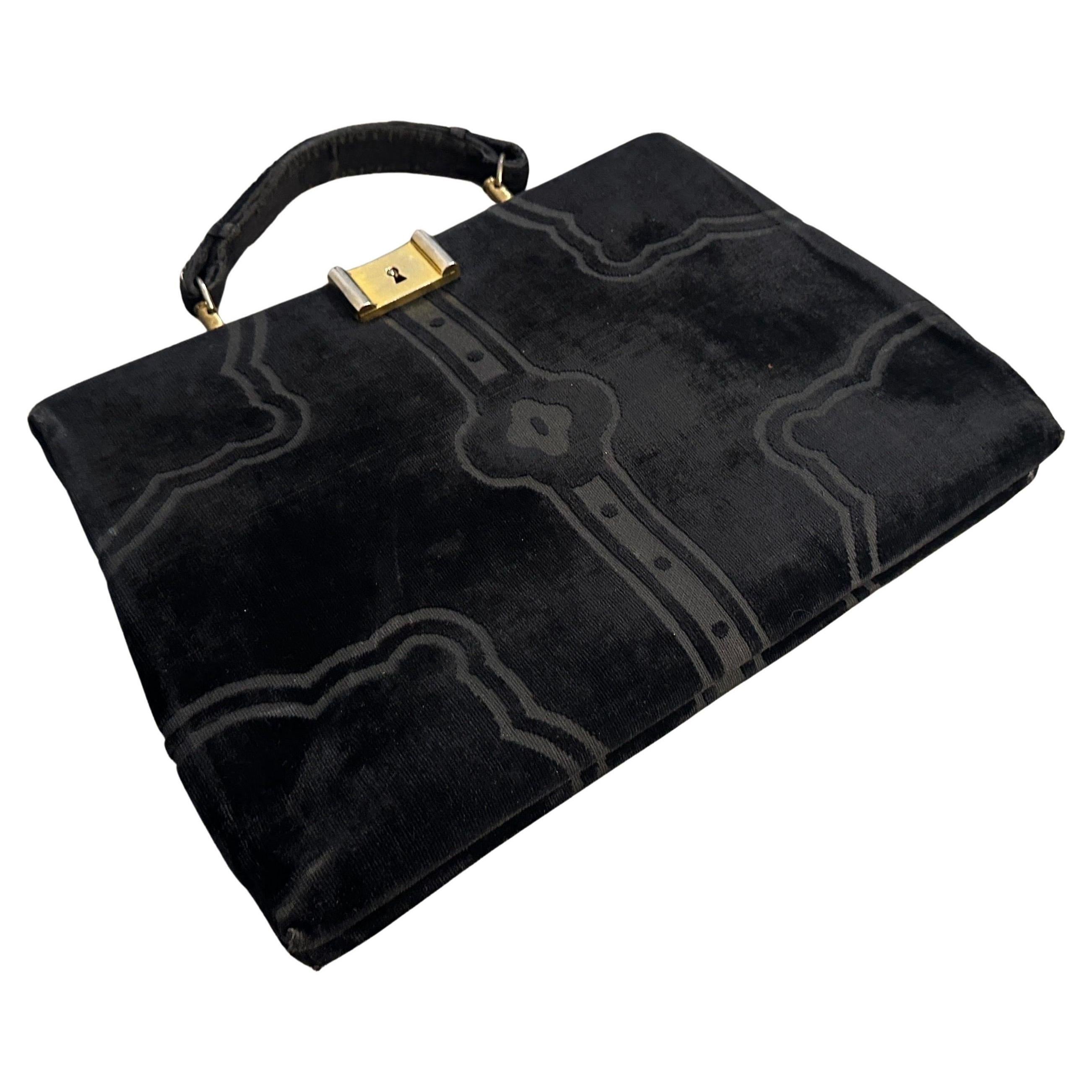 This is an iconic 1970s black velvet handbag by Roberta di Camerino, a designer renowned for her luxurious and innovative handbag designs. Made of plush black velvet, which gives it a rich and elegant texture, the bag showcases Roberta di Camerino’s