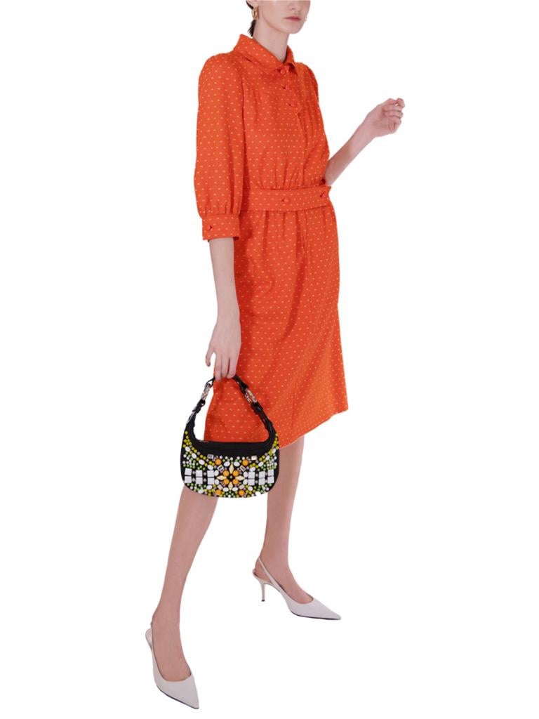 An iconic late 1970’s Courreges tangelo-orange wool mixture jersey stylized shirt-waister dress, from the Couture Future Collection, featuring an all-over jacquard woven design of the House logo in off-white, the bodice with a convertible collar,
