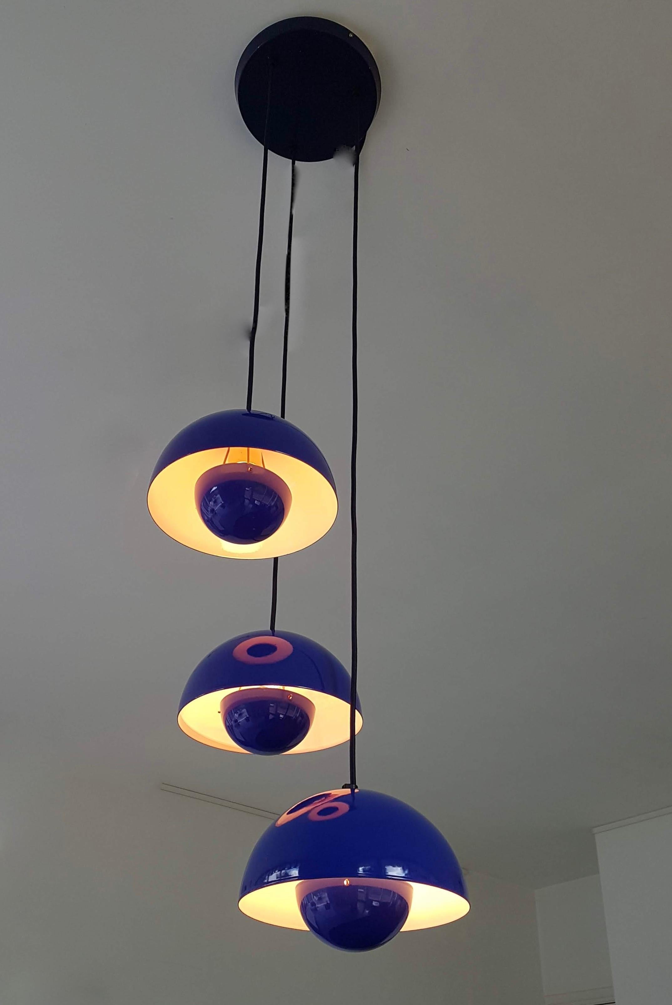 Flower Pot chandelier by Verner Panton consisting of three mounted iconic 'Flower Pot' lamps.
The flower pot, with its two enameled steel semicircular spheres facing each other, is a brilliant colourful design that was originally designed by Verner