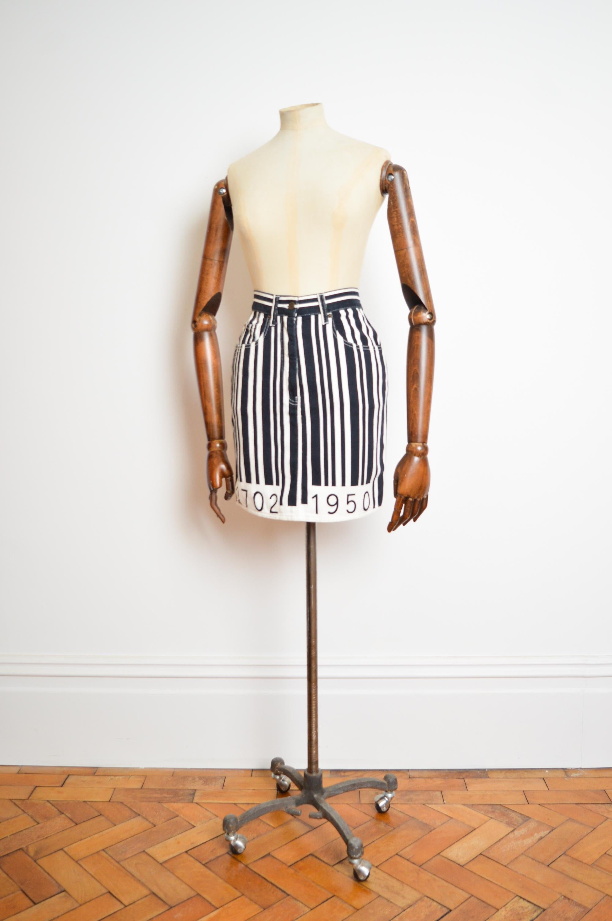 Instantly recognisable 1990's Moschino 'Cheap & Chic' label Barcode striped denim skirt, featuring a high waisted pencil fit with above the knee length hem.

MADE IN ITALY

Features:
zip / button closure
High waisted fit
Classic 4 pocket