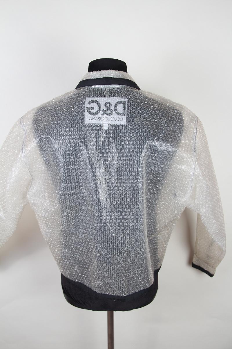 Giacca D&G by Dolce & Gabbana della collezione anni '90
Fabrice: poliuretano

Prodotto in Italia

Questa è una giacca antipioggia in pluriball. Il tipo di imballaggio che usi per la merce. La giacca ha una taglia IT 38/52 e presenta cuciture nere