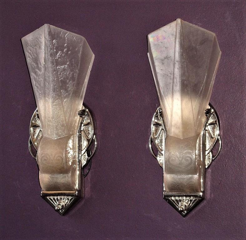 Iconic, beautiful, and rarely seen pair.

Priced per pair.

Iconic, beautiful, and rarely seen pair of very Art Deco slip shade wall sconces from the early 1930s. The shades have a deco inspired raised design on the bottom portion of the glass