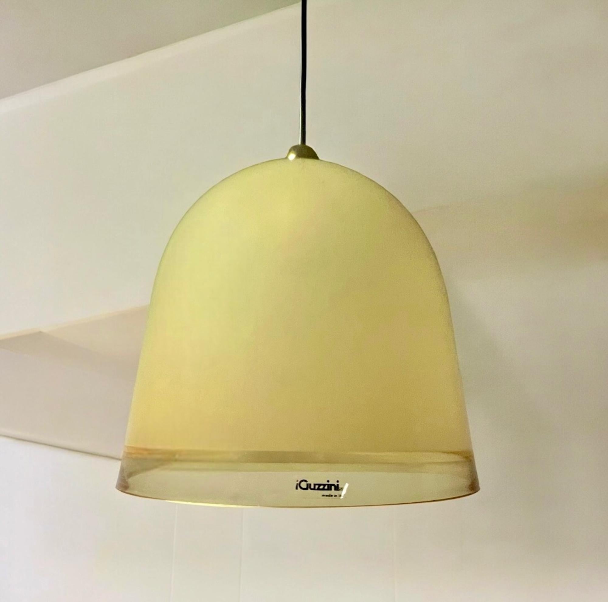 The 70s hanging lamp ‘Kuala’ 70s designed by Franco Bresciani and produced by iGuzzinifrom the late 1970s until the mid-1980s.

With a large bell-shaped conical lampshade made of thick acrylic, enhanced by translucent ochre hue, Kuala creates a warm