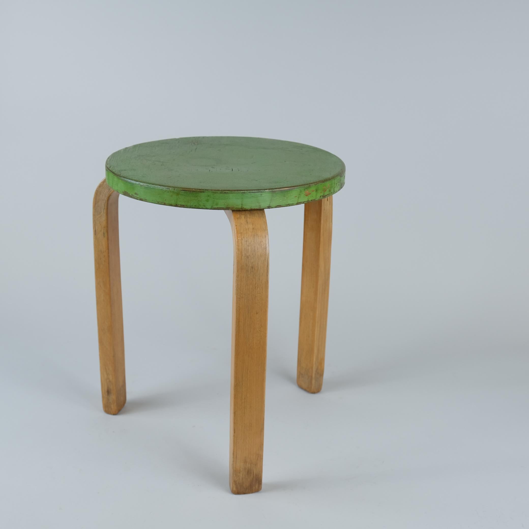 Un tabouret iconique modèle 60 en bouleau, peint en vert et 100%...  belle patine unique. Conçu par Alvar Aalto pour Artek dans les années 1930, ce design a définitivement résisté à l'épreuve du temps, puisqu'il est toujours en production et reste
