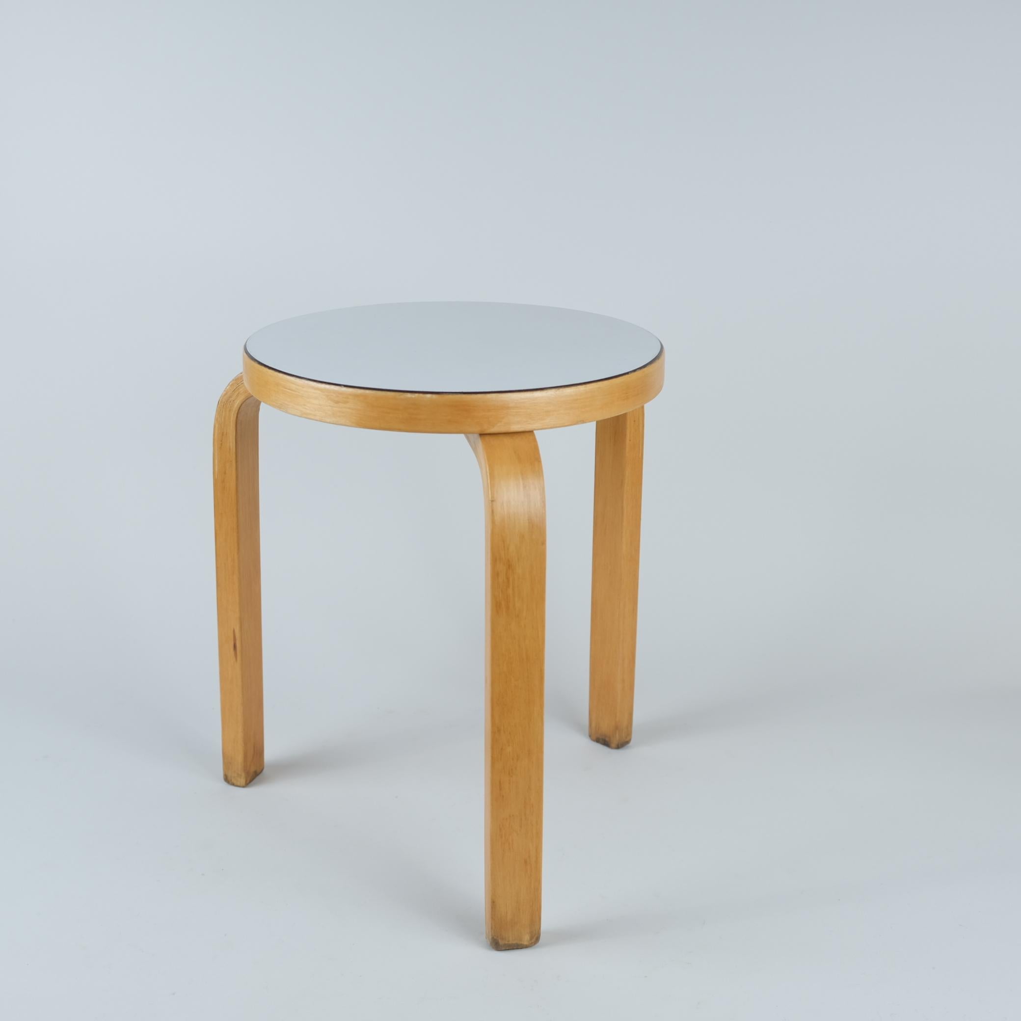 Ein ikonischer Hocker Modell 60 aus Birke und weißem Formica. Dieses von Alvar Aalto in den 1930er Jahren für Artek entworfene Design hat sich definitiv bewährt, denn es wird immer noch produziert und ist bei den Verbrauchern nach wie vor eines der