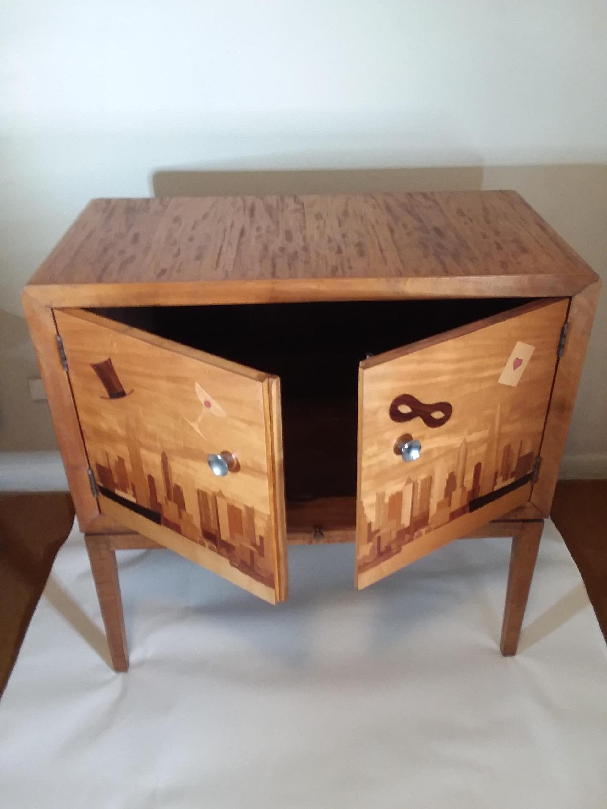 Amazing Art Deco New York dry bar cabinet inlaid with exotic woods with a skyline view of NY from the New Jersey side. Exotic woods in different tones are used to depict the booming skyline as well as a pair of black steamer ships coming into port