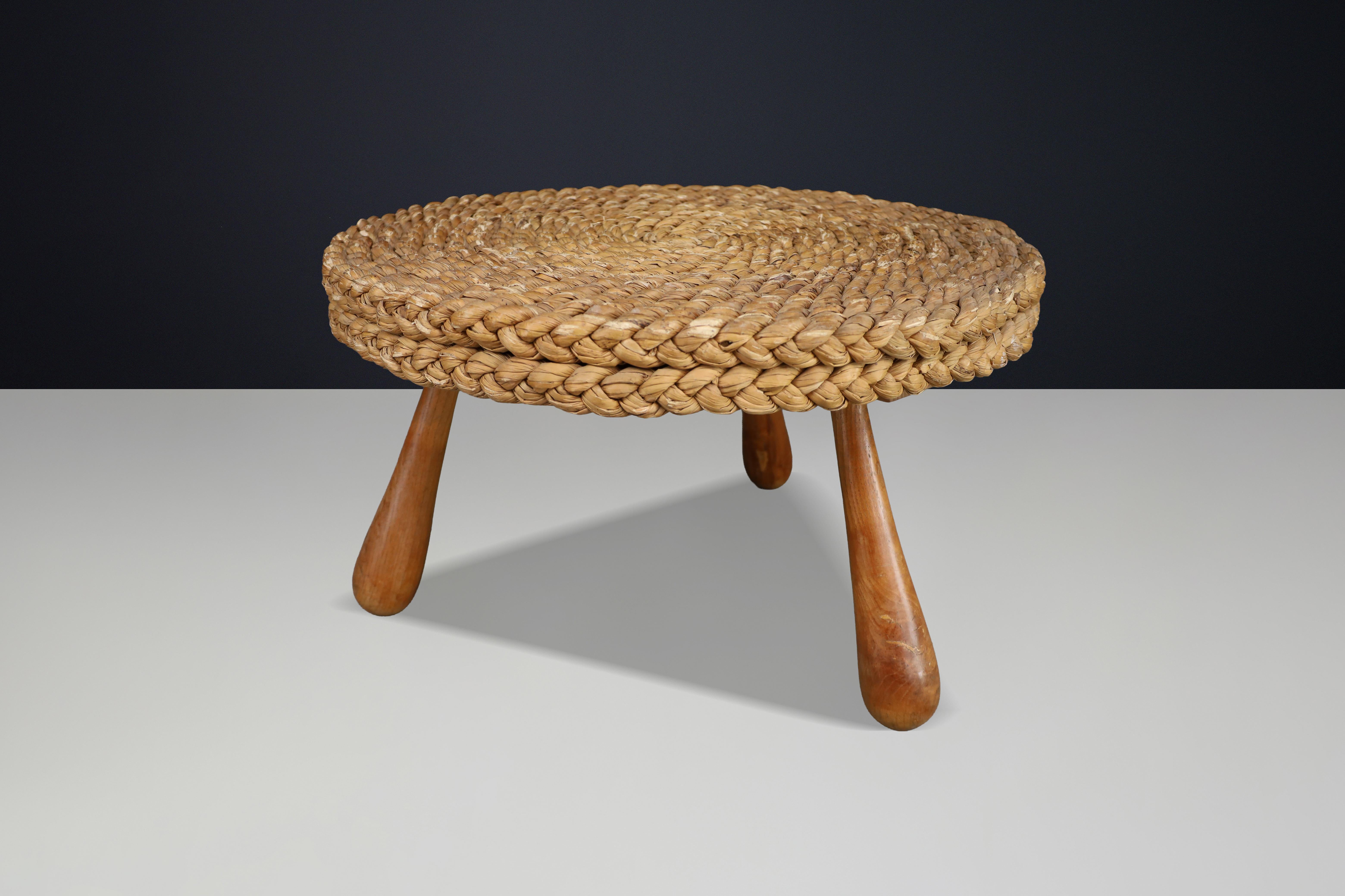 Sculptural rope side table by Audoux & Minet, France, 1950s, featuring a hand-woven straw top and solid turned wooden legs with beautiful natural patina.

This elegant and sculptural side or coffee table was designed by Audoux & Minet in France