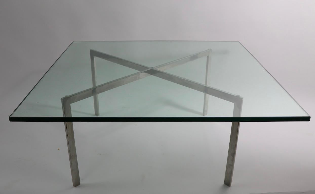 Classic Barcelona coffee table, designed by Mies Ver Der Rohe. This example is in good original vintage condition, the glass shows some surface scratches, normal and consistent with age, the base is bright and clean, unsigned. Glass top .75 inch