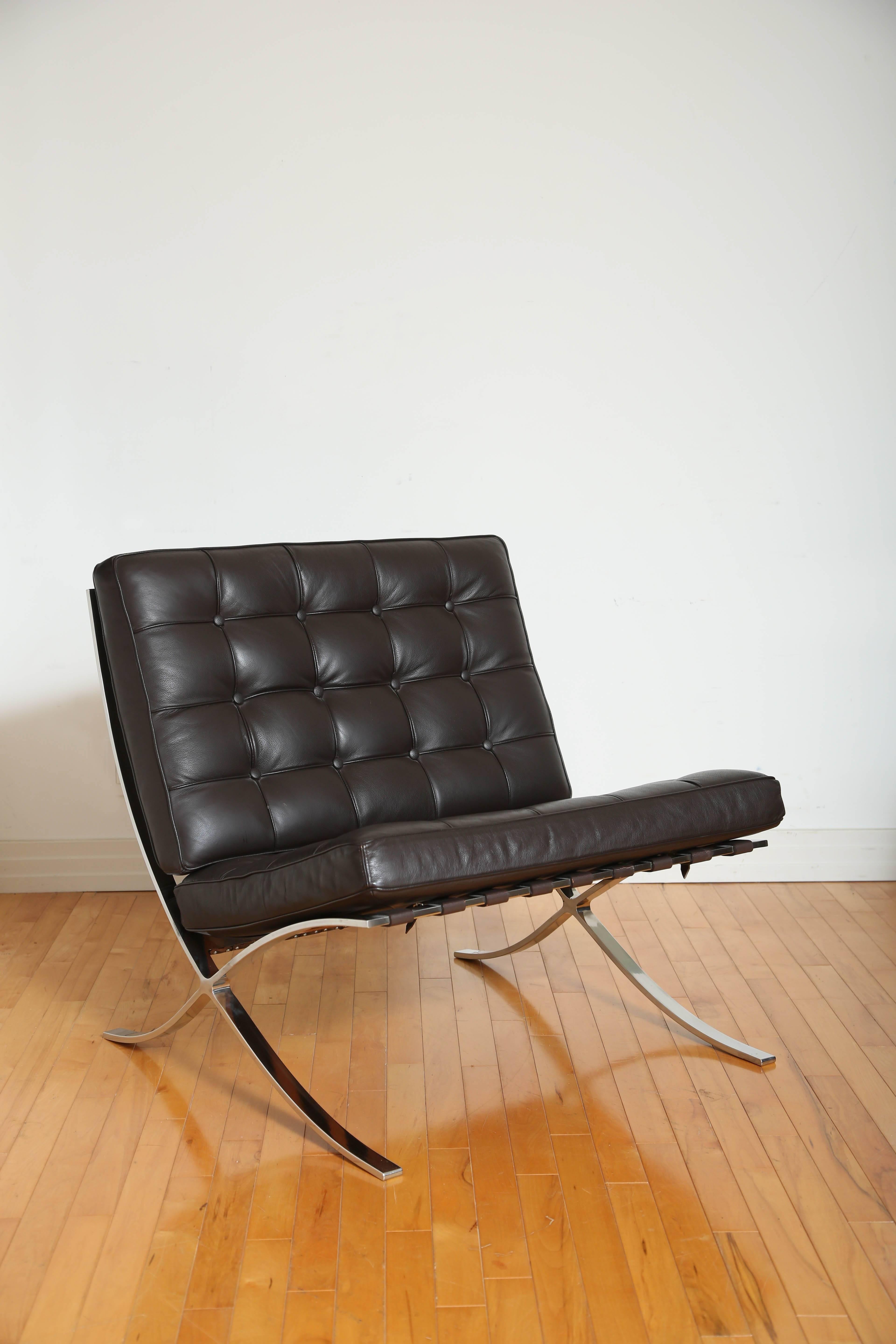 Vintage Barcelona lounge chair in espresso brown leather.  Iconic design originally manufactured during the Bauhaus Movement, circa 1929.  The chair has a slight recline, and features leather slats along the back with tufted seat cushions. Suited