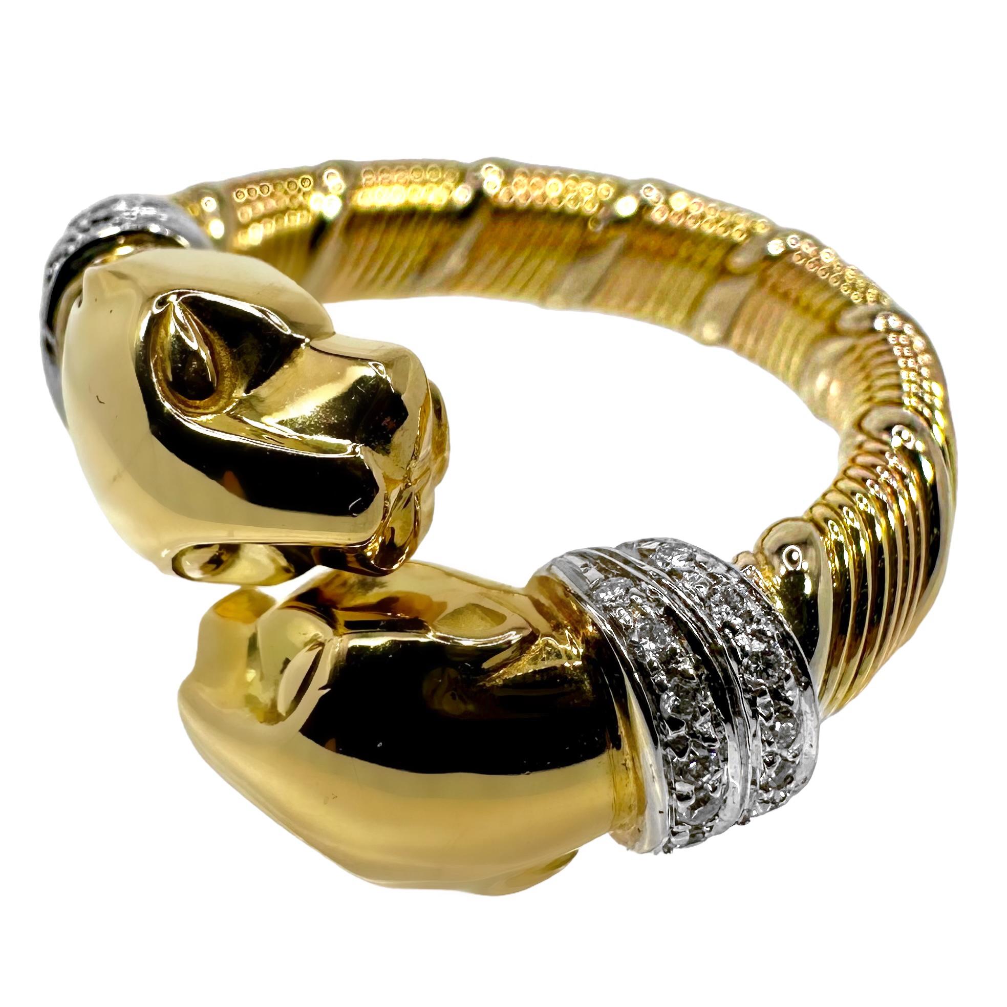 This striking and iconic Cartier ring crafted in 18k yellow gold and diamonds, is an elegant example of the venerated house's exquisite jewelry design and execution. Two panther heads bypass each other at the front and each wears a collar set with