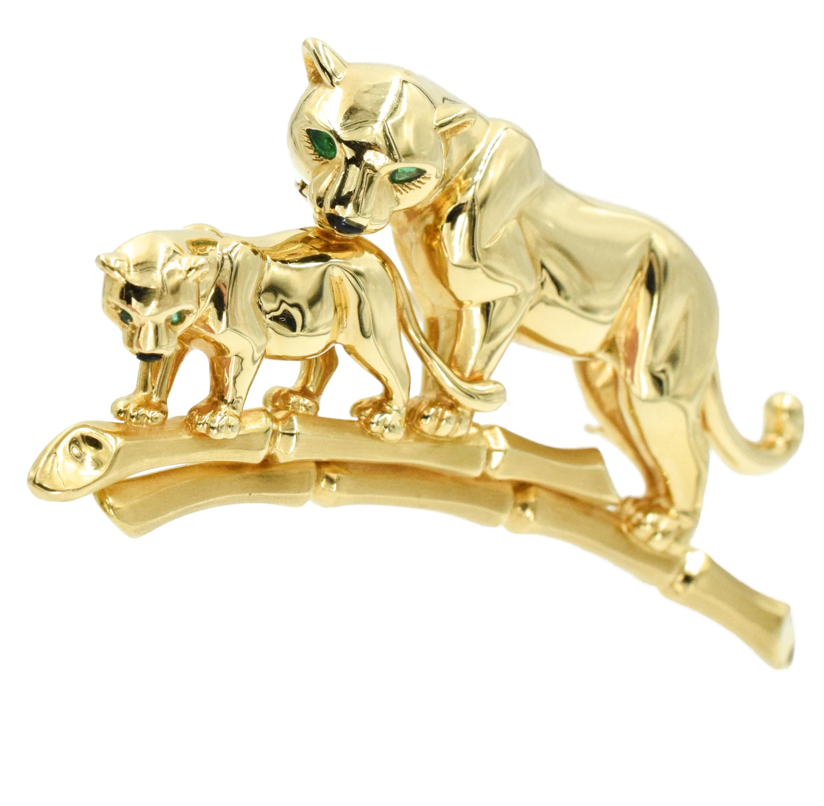 Cartier Panthere Gold Brooch. This brooch has a large and small gold panther with emerald eyes on a gold bamboo branch.
 Signed Cartier, 750, Serial No. xxxxx.  
18k gold
Made in France