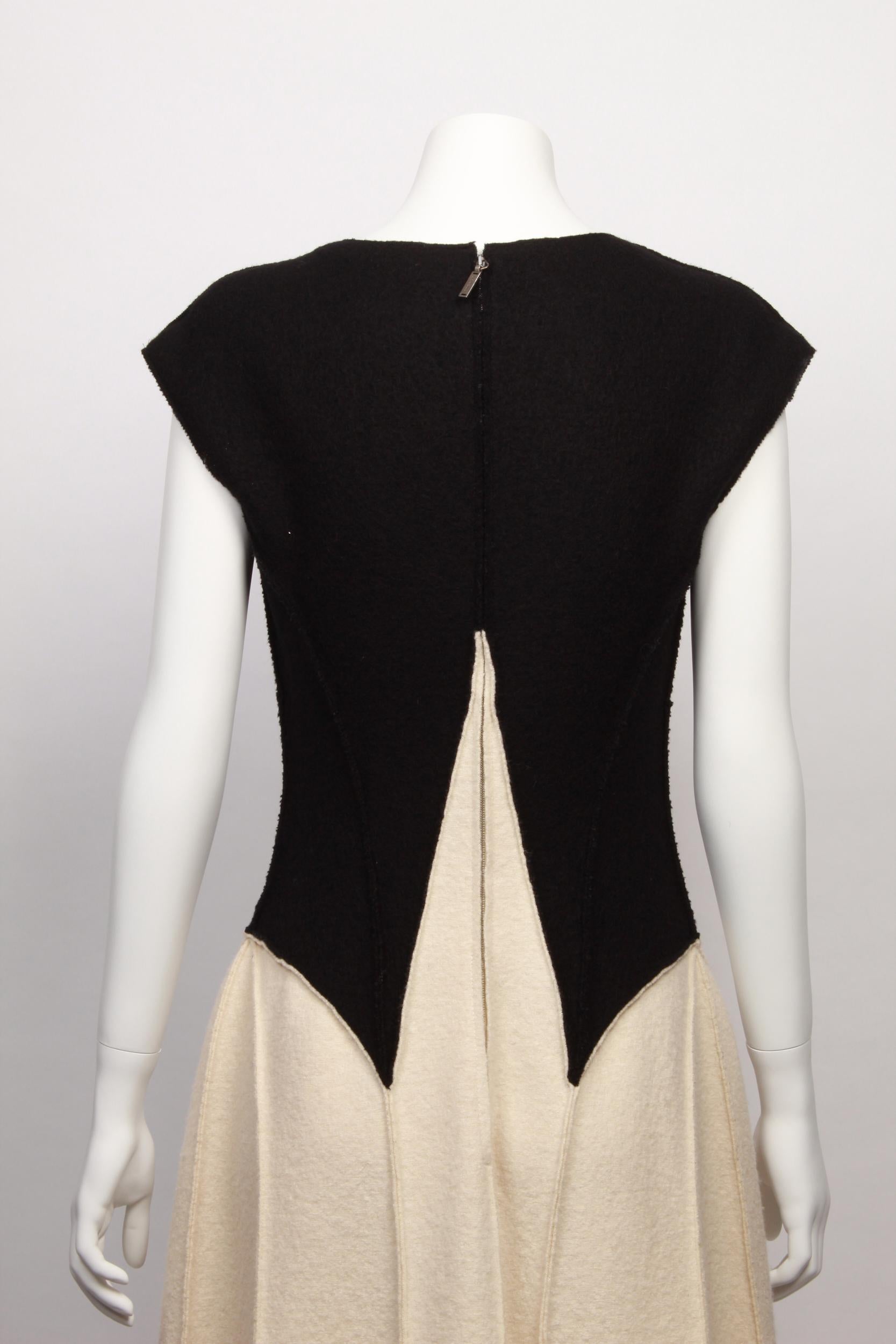 Black and ivory Chanel wool gown from the Autumn 1999 collection. Designed by Karl Lagerfeld. 
 Features exposed seams, interlocking CC decorative medallion and concealed back zipper with chanel logo. 
Made in France. 100% wool with silk lining.