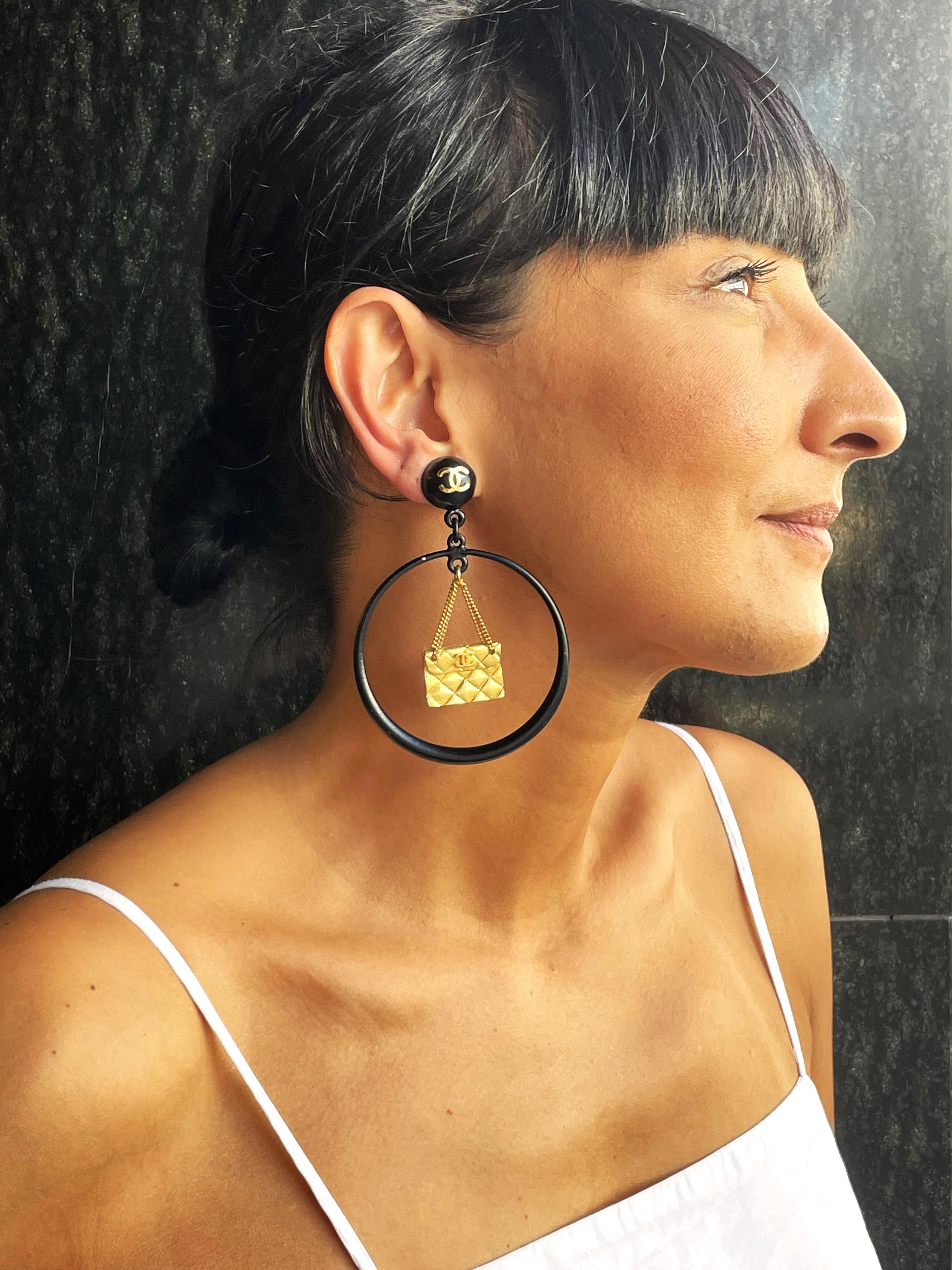 Iconic black enamel CHANEL Clip-on earrings. A large Circle in this hangs the iconic gold-colored quilted CHANEL Bag. 
The black circle hangs from a black enamel hemisphere decorated with a gold CHANEL CC, 1,7 cm in diameter.

Measurement 
Full