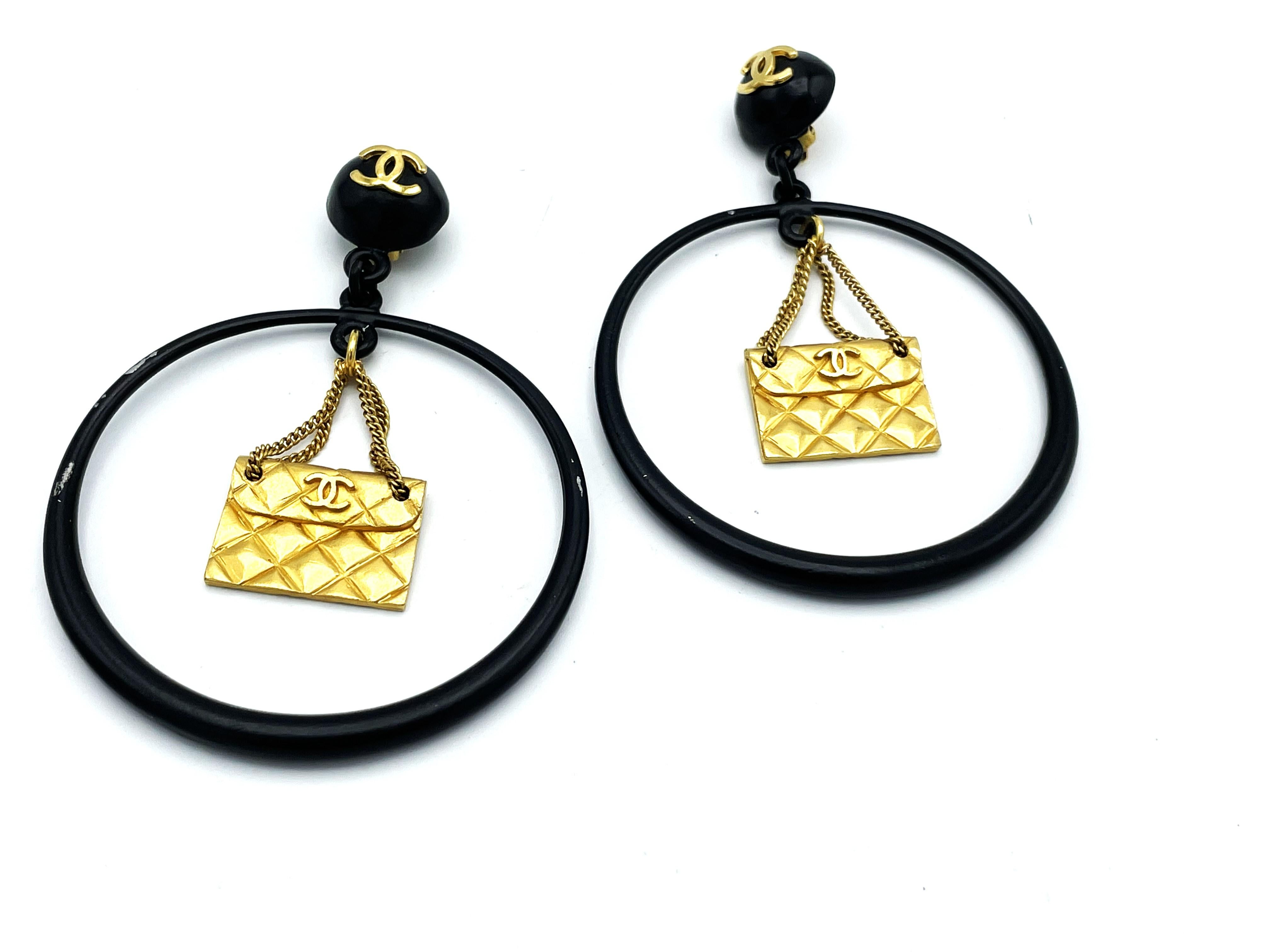 Modern Iconic Chanel black Circle clip-on earring with gold Chanel bag hanging, 1990s For Sale