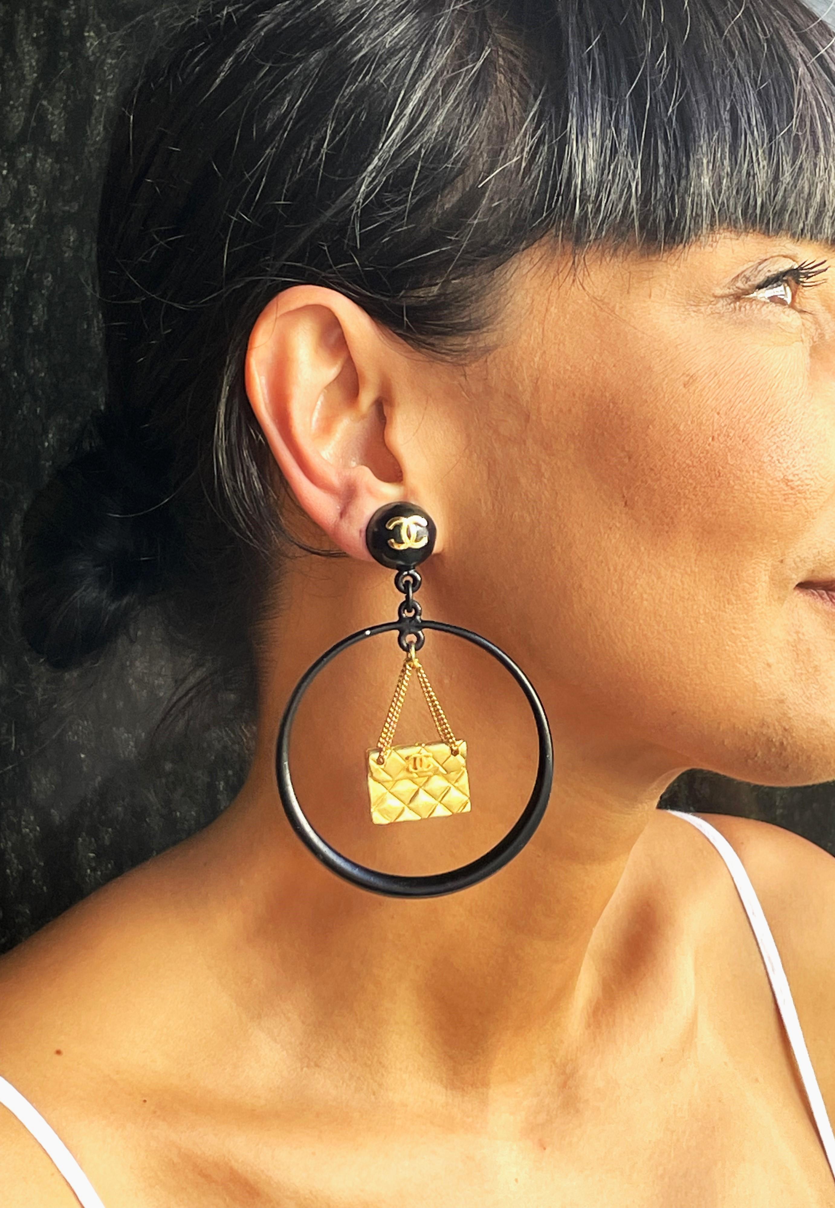 Women's Iconic Chanel black Circle clip-on earring with gold Chanel bag hanging, 1990s