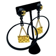 Retro Iconic Chanel black Circle clip-on earring with gold Chanel bag hanging, 1990s