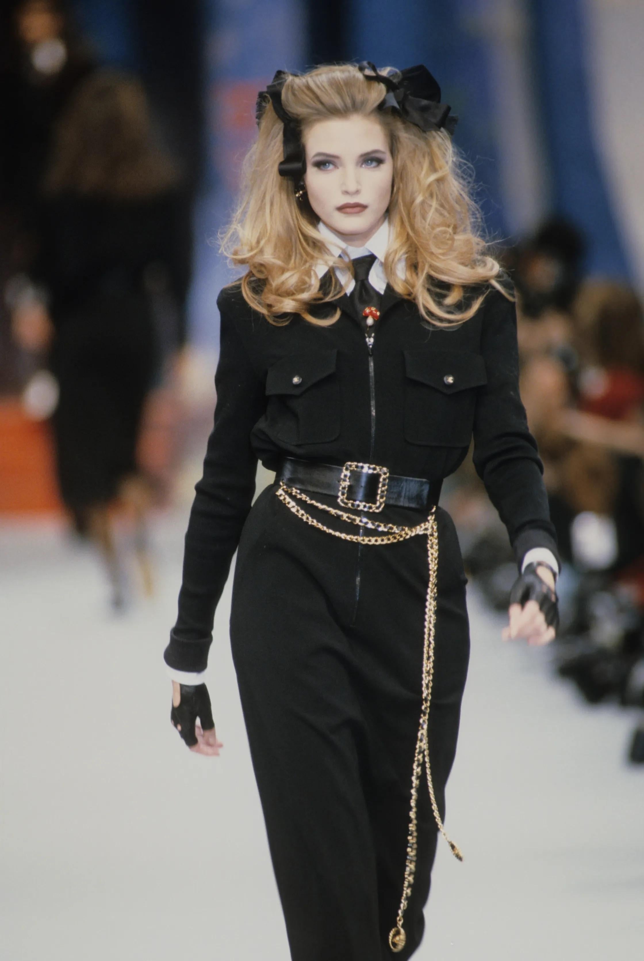 This iconic black dress from the Chanel Spring/Summer 1992 collection epitomizes Karl Lagerfeld's distinctive style. For an uber-cool look, pair it with a cropped white shirt underneath, a chunky waist belt, and black sunglasses. The dress features