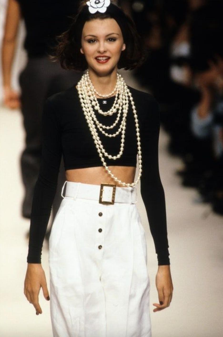 The most wanted black cropped top from the Chanel Spring 1995 collection!  It is considered one of the most sought-after items from the 90s, beloved by collectors worldwide. This iconic garment features long sleeves and a contrasting white CC logo