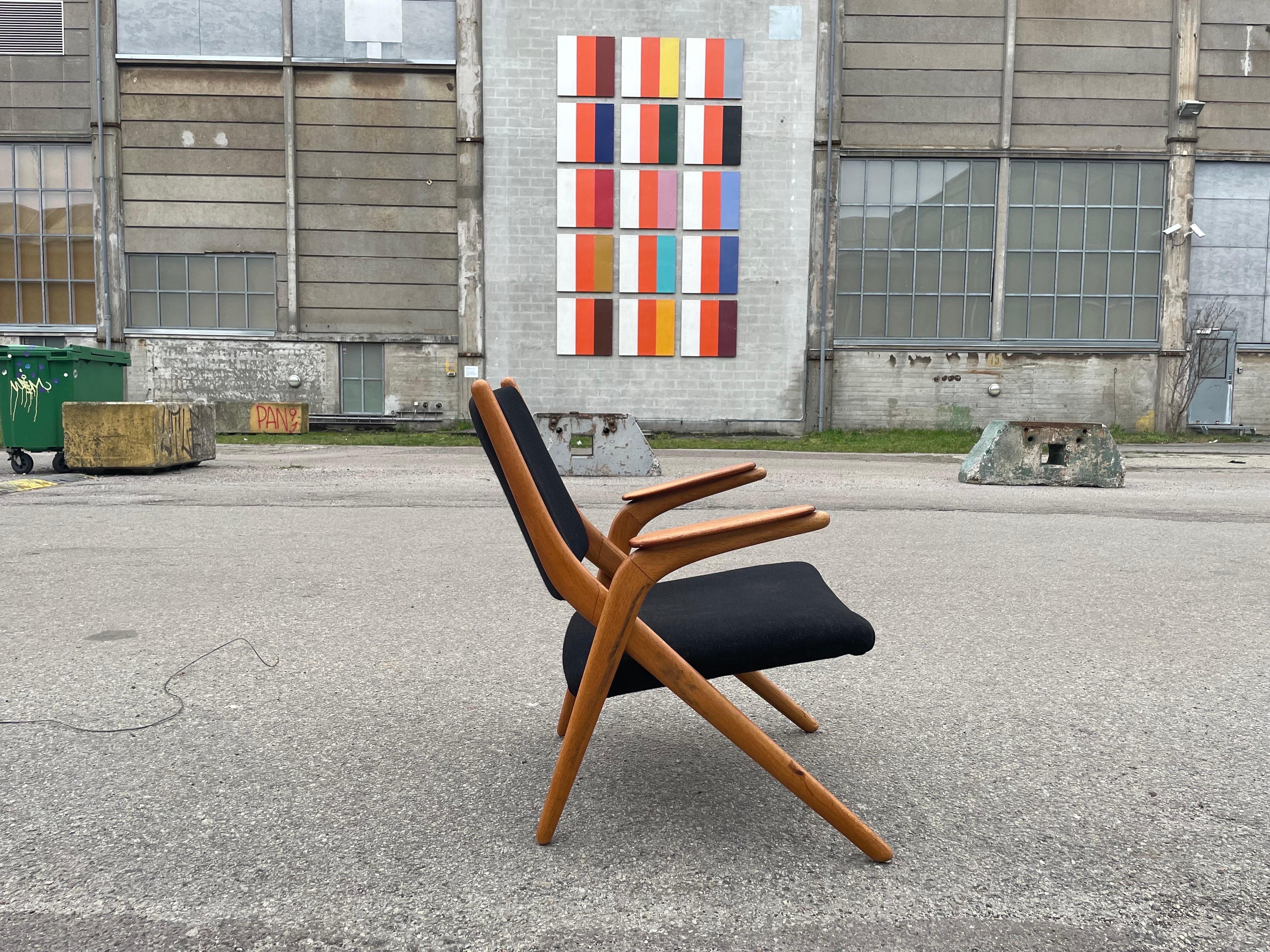Rare Danish Modern Scissor Lounge Chair in Teak + Beech from 1960. This unique piece embodies mid-century design, showcasing craftsmanship and style in perfect harmony.