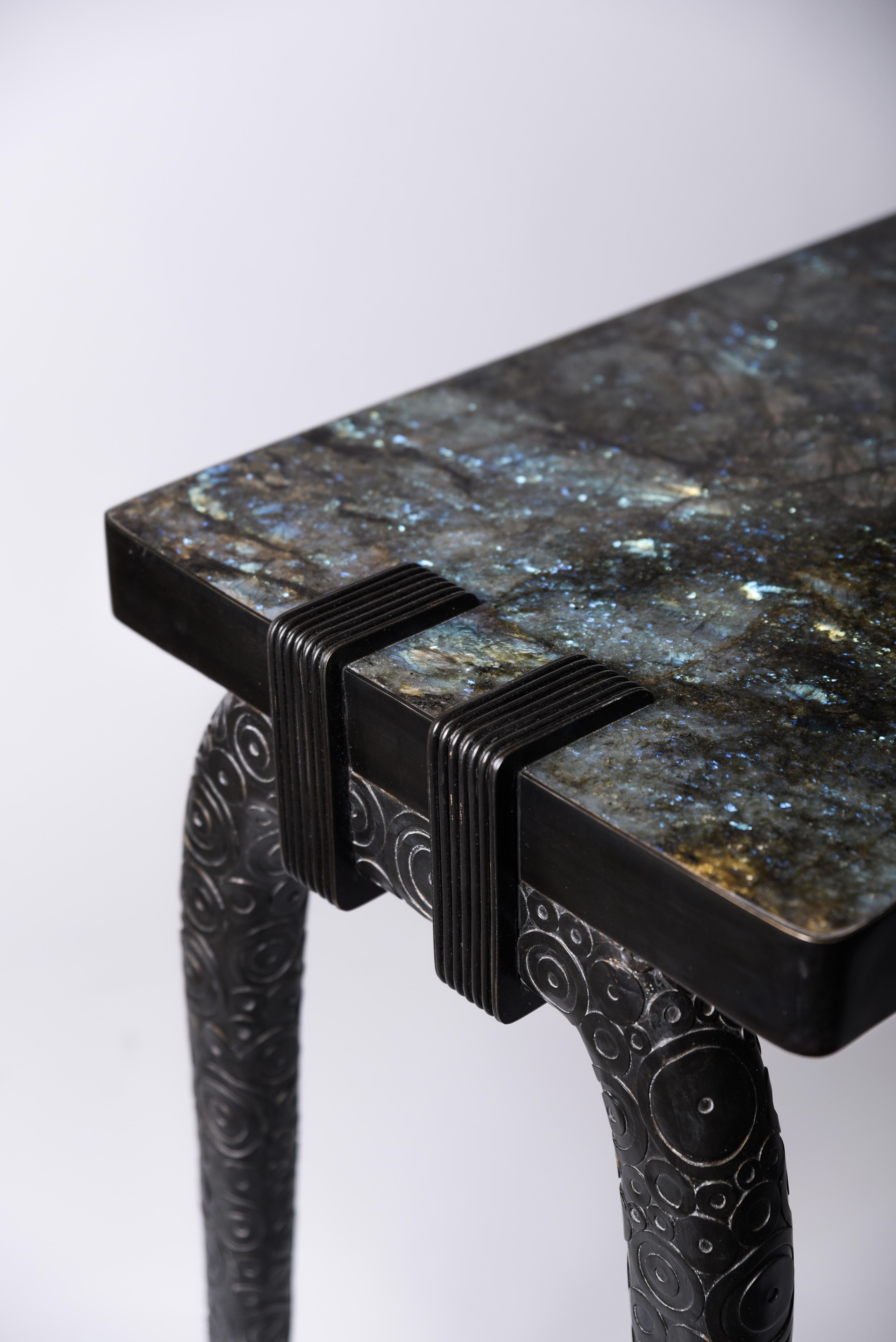 The iconic console is the perfect statement piece for any room. An incredible “duo” between the dreamy Lemurian top, with blue and black tonalities in it, and the dark bronze-patina brass base. The circle inlay work on the legs makes this piece