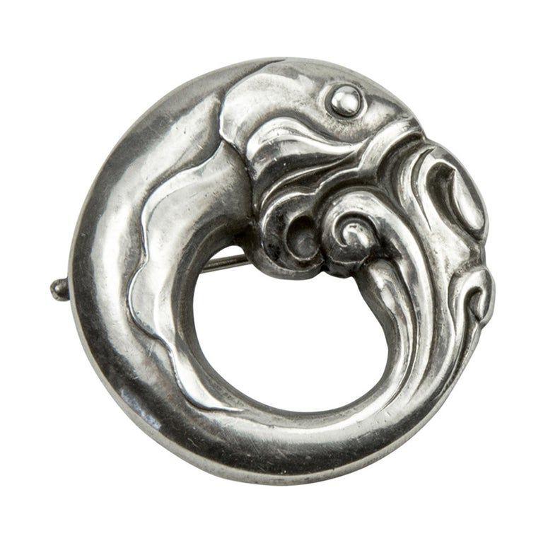 Simply Beautiful! Early design Georg Jensen Brooch depicting a Curled Fish flowing around the entirety; measuring approx. 1.19” in diameter; Hallmarks: Georg Jensen in dotted oval, 830, Denmark, 10. Circa 1940s. More Beautiful in real time! Sure to