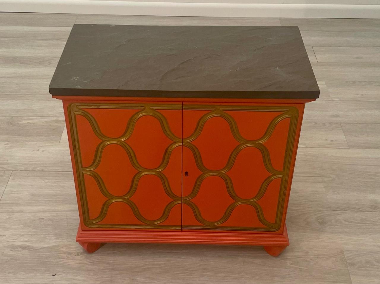 The iconic Espana design cabinet in a striking Hermes orange with gold decoration and black slate top. Stamped Dorothy Draper for Henredon.
In great condition and timeless.