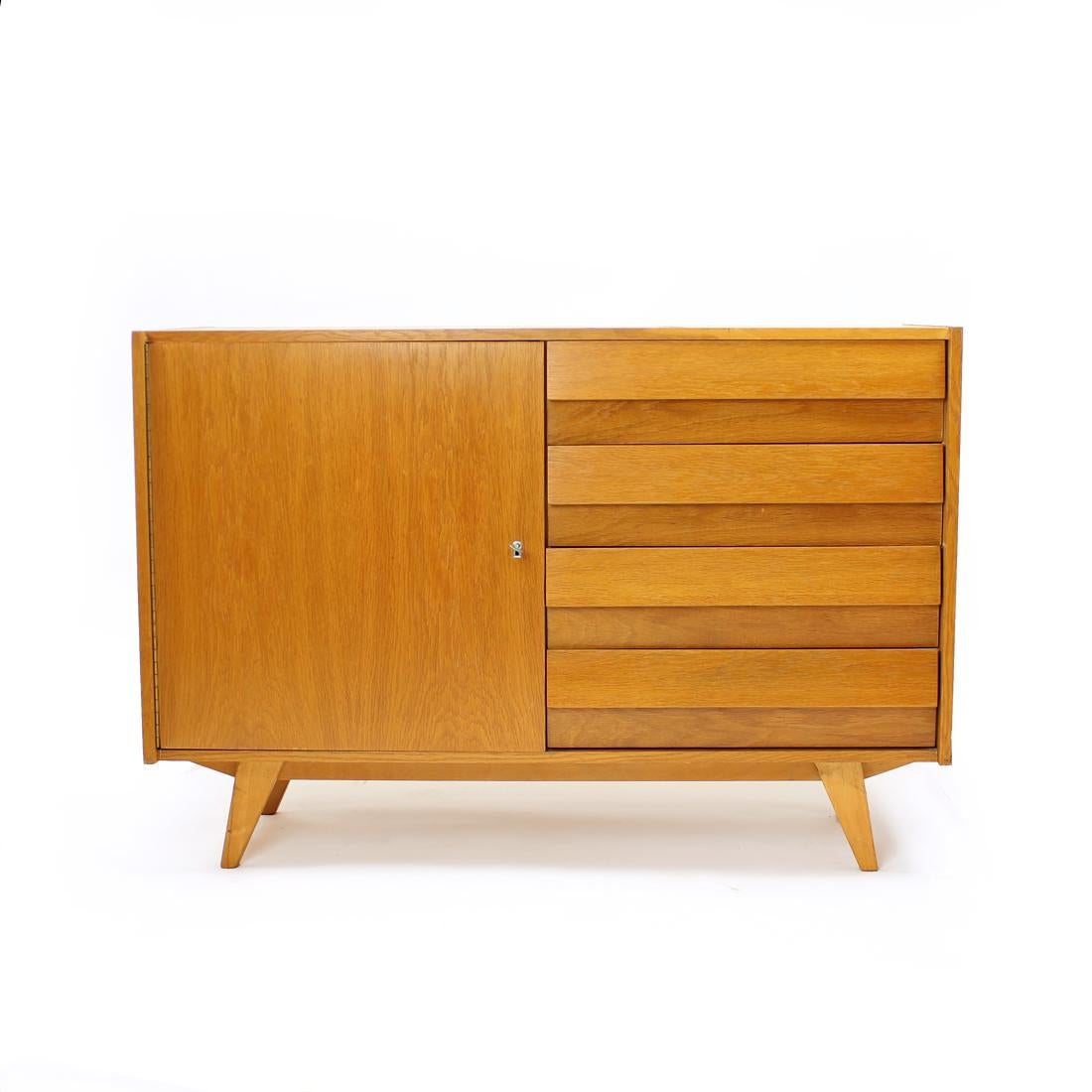 Iconic sideboard designed by Jiri Jiroutek for Interier Praha in 1960s, original label still sttached. The sideboard in in half drawer, half compartment version. On the right side there are four drawers, plastic inside, oak wood fronts. The left