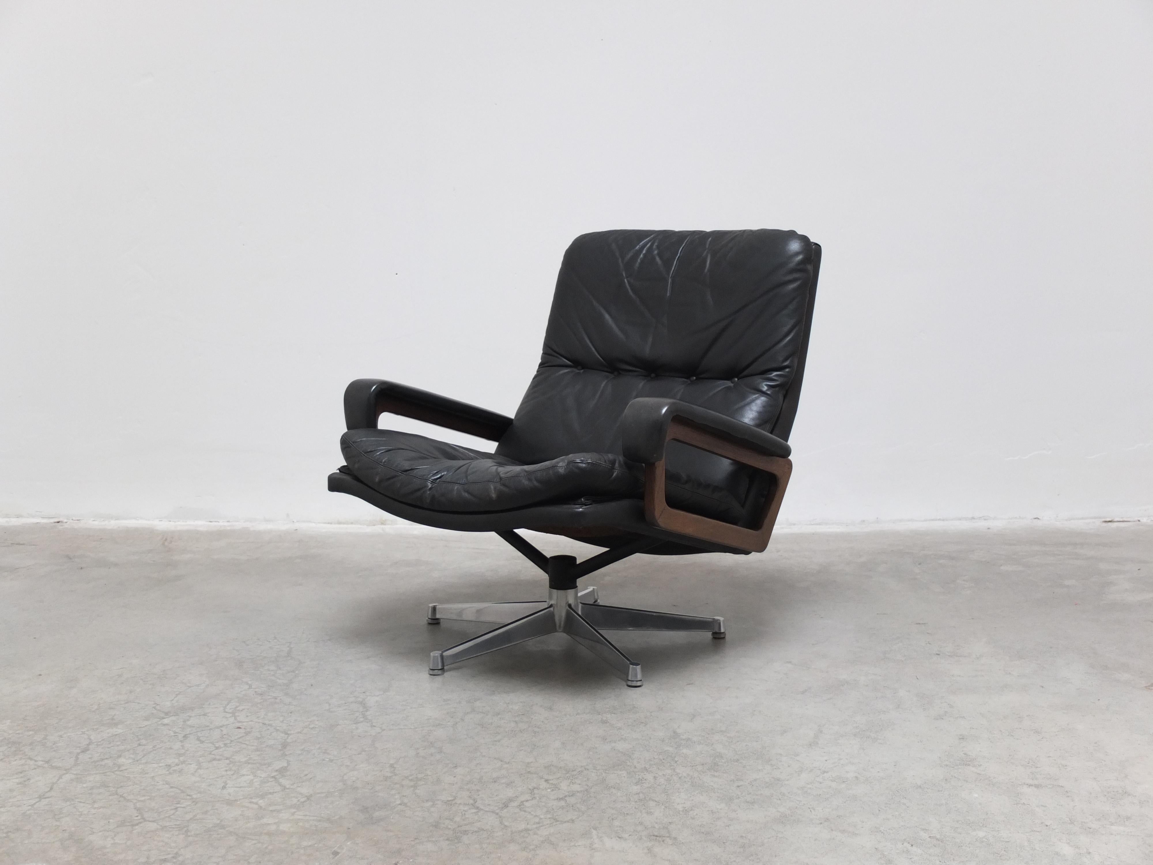 Iconic ‘King’ lounge chair designed by Swiss architect André Vandenbeuck for Strässle during the 1960s. This is a black leather edition with wooden armrests and the early star-shaped metal base. Labeled by the maker and in very good original