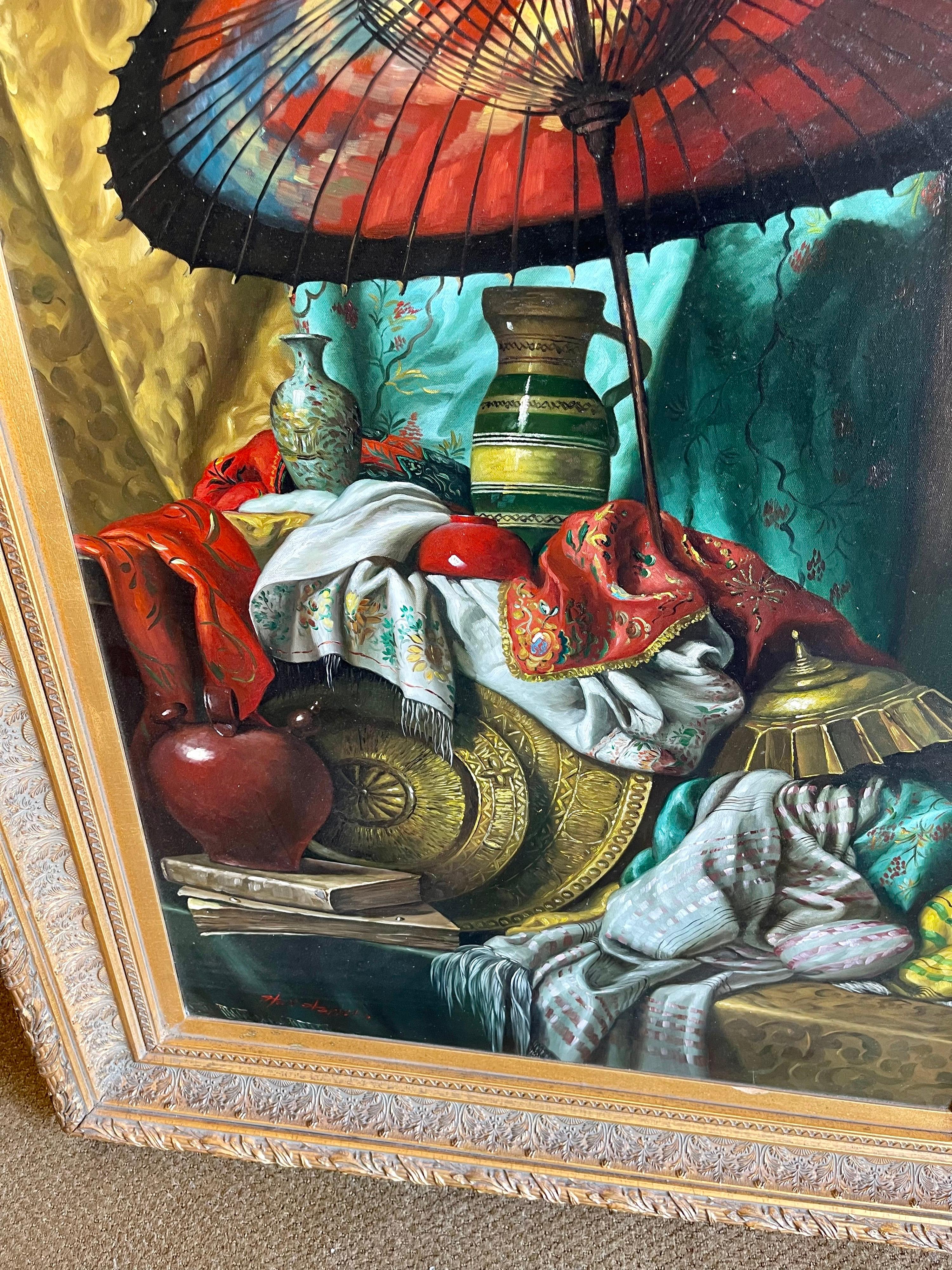 A sumptuous large still life oil painting displaying a Chinese parasol, brass wares and silk fabrics. Very luxurious. Signed by the artist at bottom rather illegibly. Displayed in a fine giltwood frame.