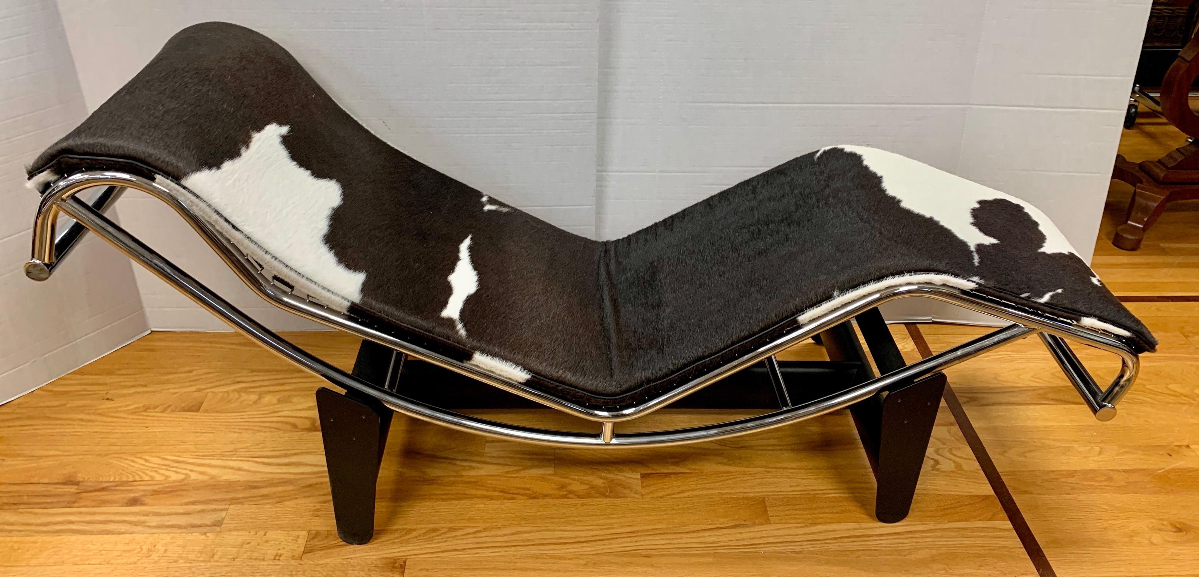 Iconic Le Corbusier style LC4 chaise with adjustable inclination upholstered in brown and white cowhide. Tilt it to suit your needs from upright to a full recline. The LC4 conforms to the bodies natural curves. Base element in metal and steel,
