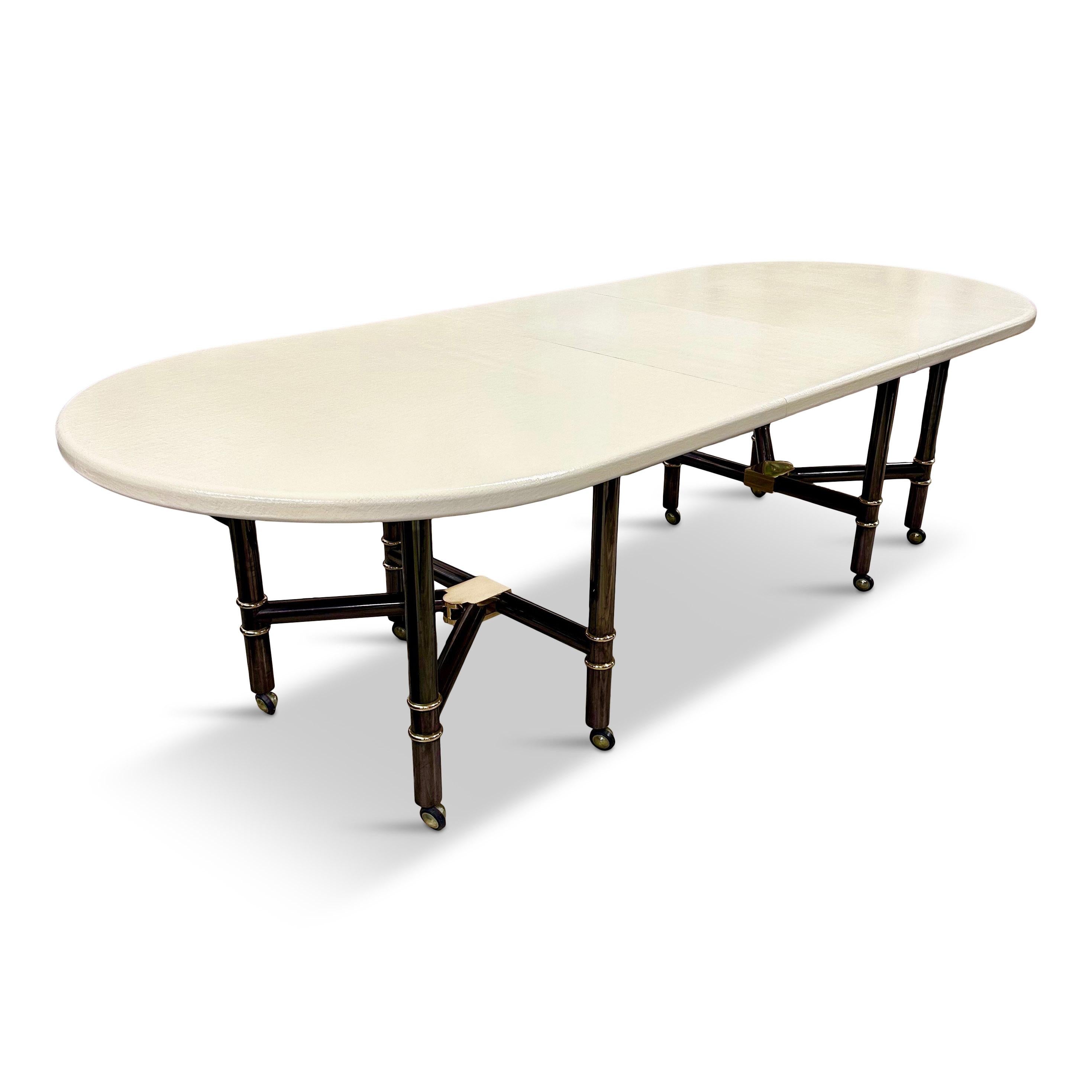 This is perhaps Maison Jansen's most iconic design ever made. This incredibly rare table, of which only a dozen or less are even in the world. This is a foldable dining table, that has a canvas texture and gunmetal steel and brass folding legs with