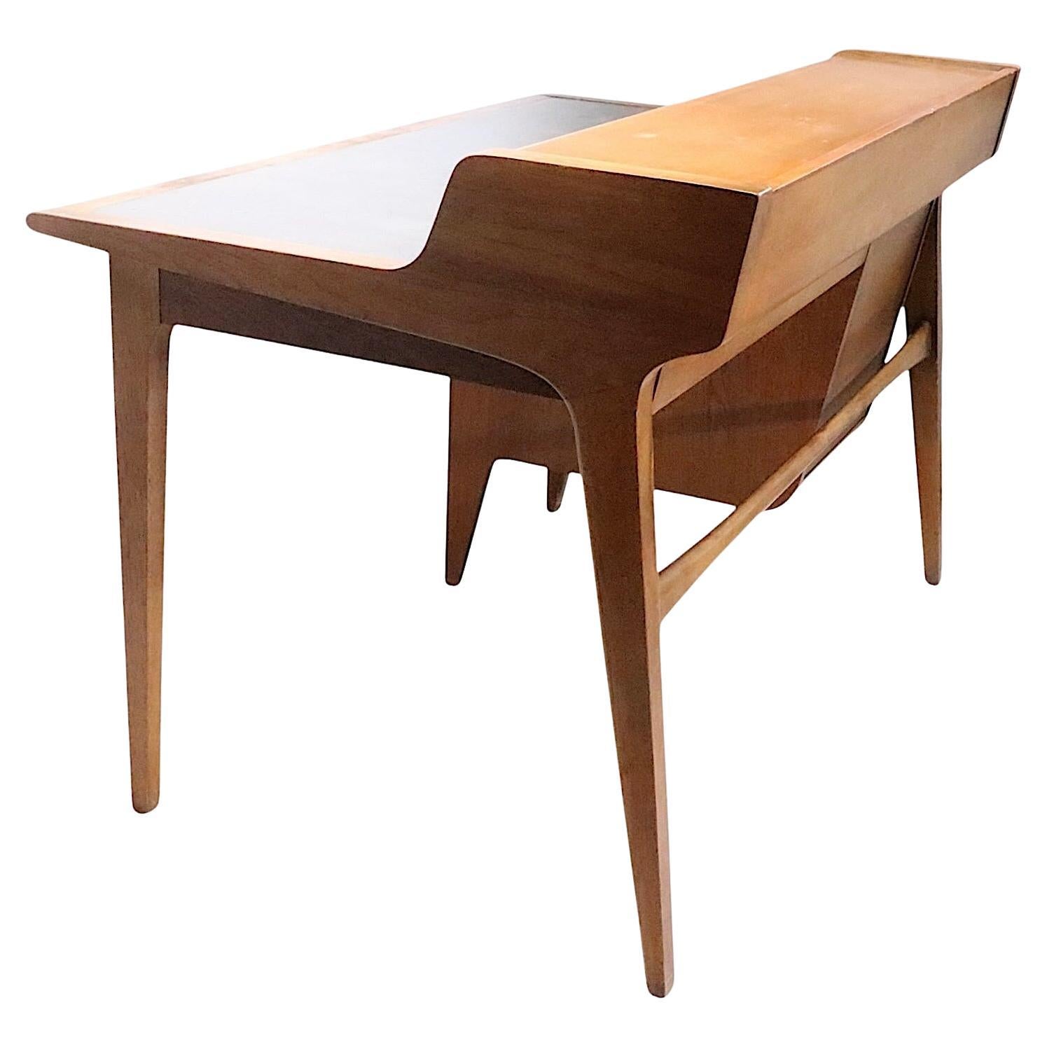Bureau classique du milieu du siècle, conçu par John Van Koert pour Drexel, vers les années 1960. Ce bureau élégant est doté d'un plateau à deux niveaux, la partie supérieure comportant deux portes coulissantes qui s'ouvrent pour révéler un espace