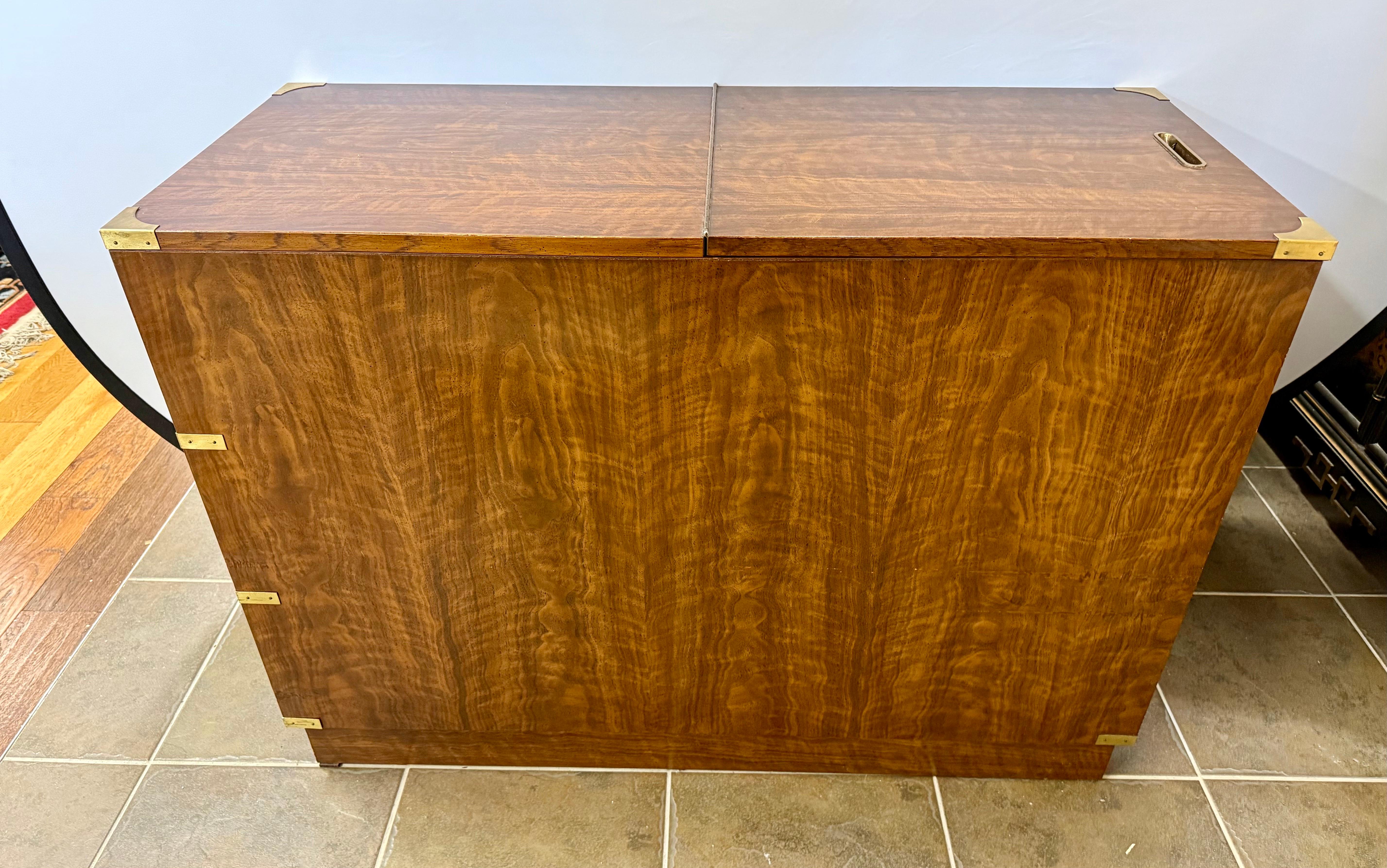 Coveted signed Drexel Furniture Campaign style dresser/chest/dry bar from their rare Brigade line. Has 3 drawers in front and lift up hidden cabinet in back. Features signature campaign style brass hardware and pulls. This versatile piece can be