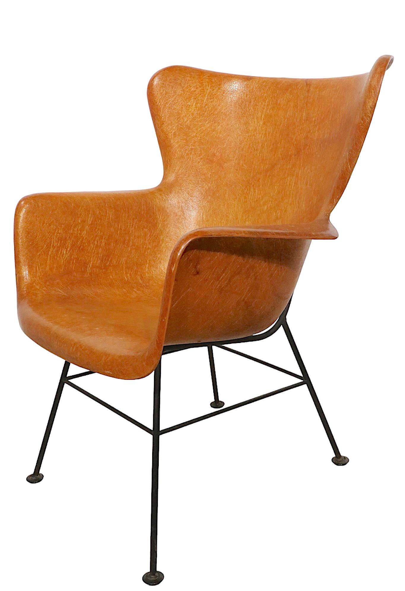 Iconic fiberglass and wrought iron modernist reinterpretation of the classic wing chair form, designed by Lawerence Peabody, manufactured by Selig, circa 1950's. 
 This example is in original, untouched vintage estate condition, showing only