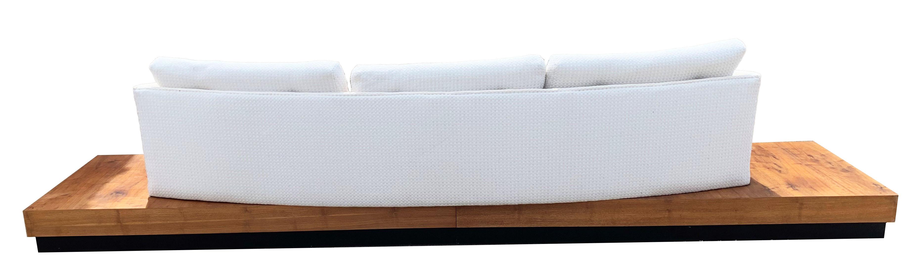 This Iconic and incredible low-profile Mid-Century Modern platform sofa is designed by Adrian Pearsall for Craft Associates. The back of the sofa is curved and sits on an amazing walnut plinth base. The piece is Fully reupholstered and in excellent
