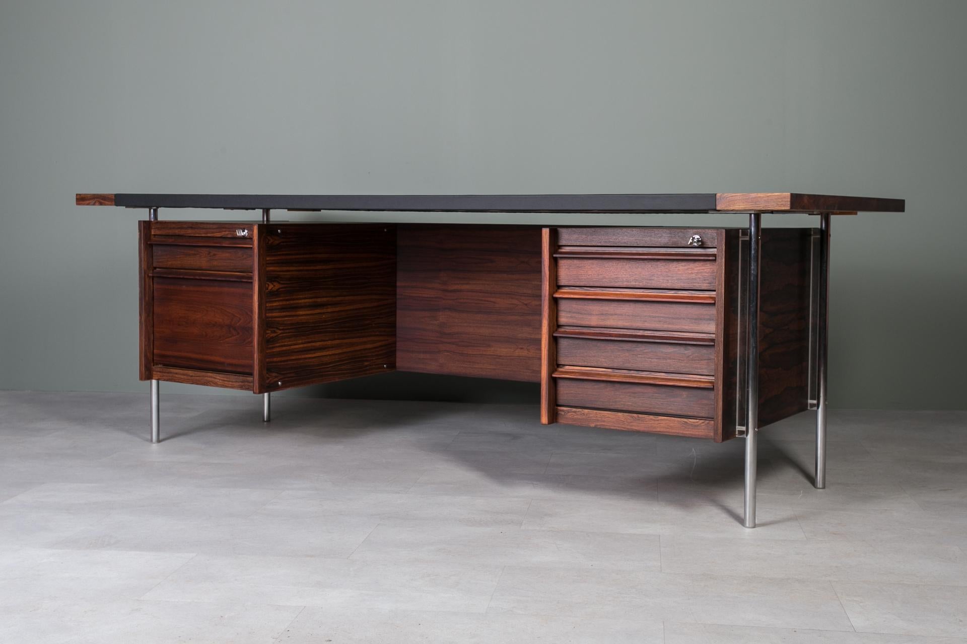 This exceptional desk by renowned Norwegian designer Svend Ivar Dysthe is a masterful example of Scandinavian modernism from the 1960s, made by Dokka Mobler. Veneered with beautiful exotic wood, the desk showcases its stunning natural grain, with a
