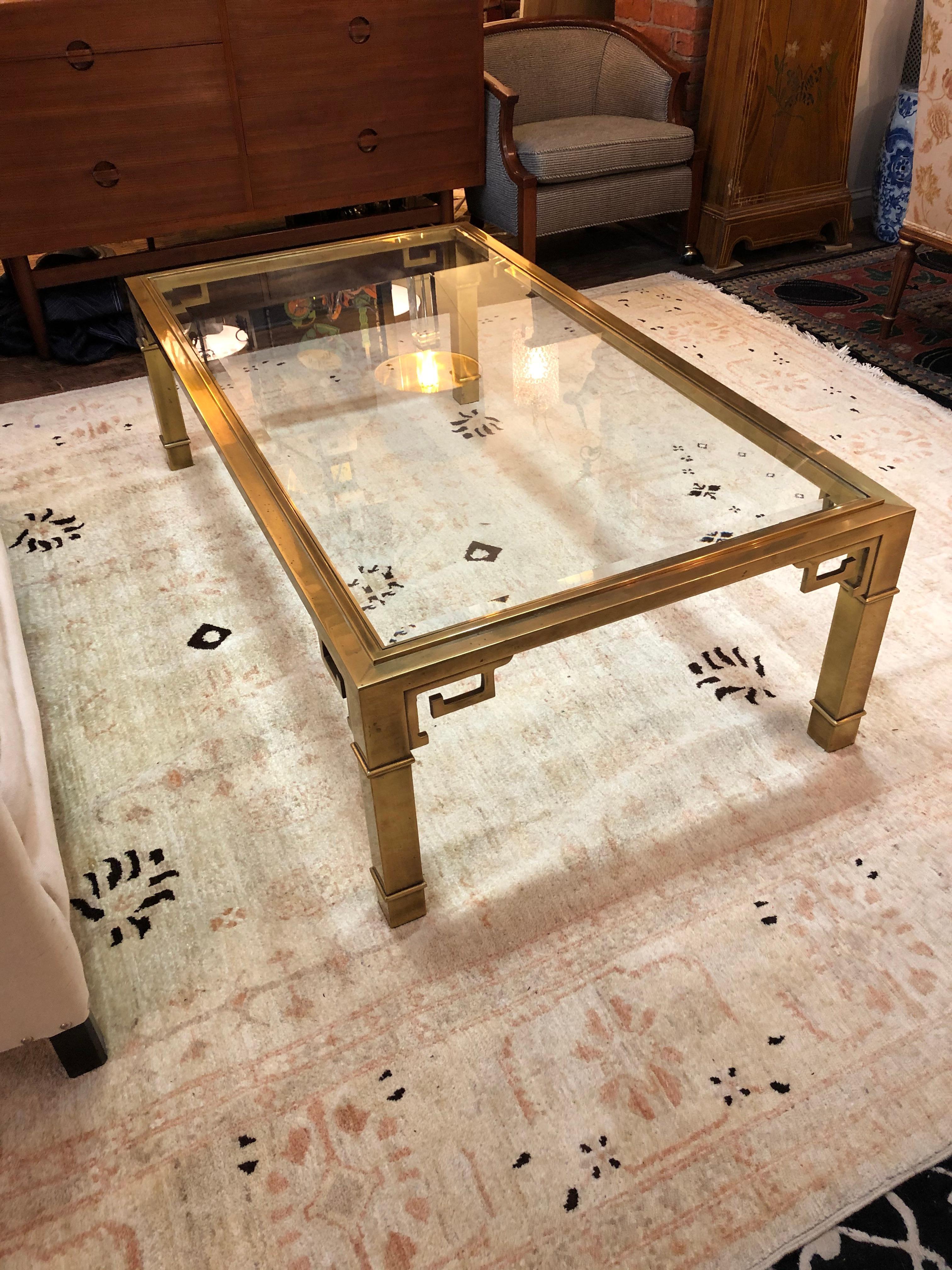 Iconic Mid-Century Modern Mastercraft rectangular coffee table having brass base with Greek key corner details and beveled glass top.