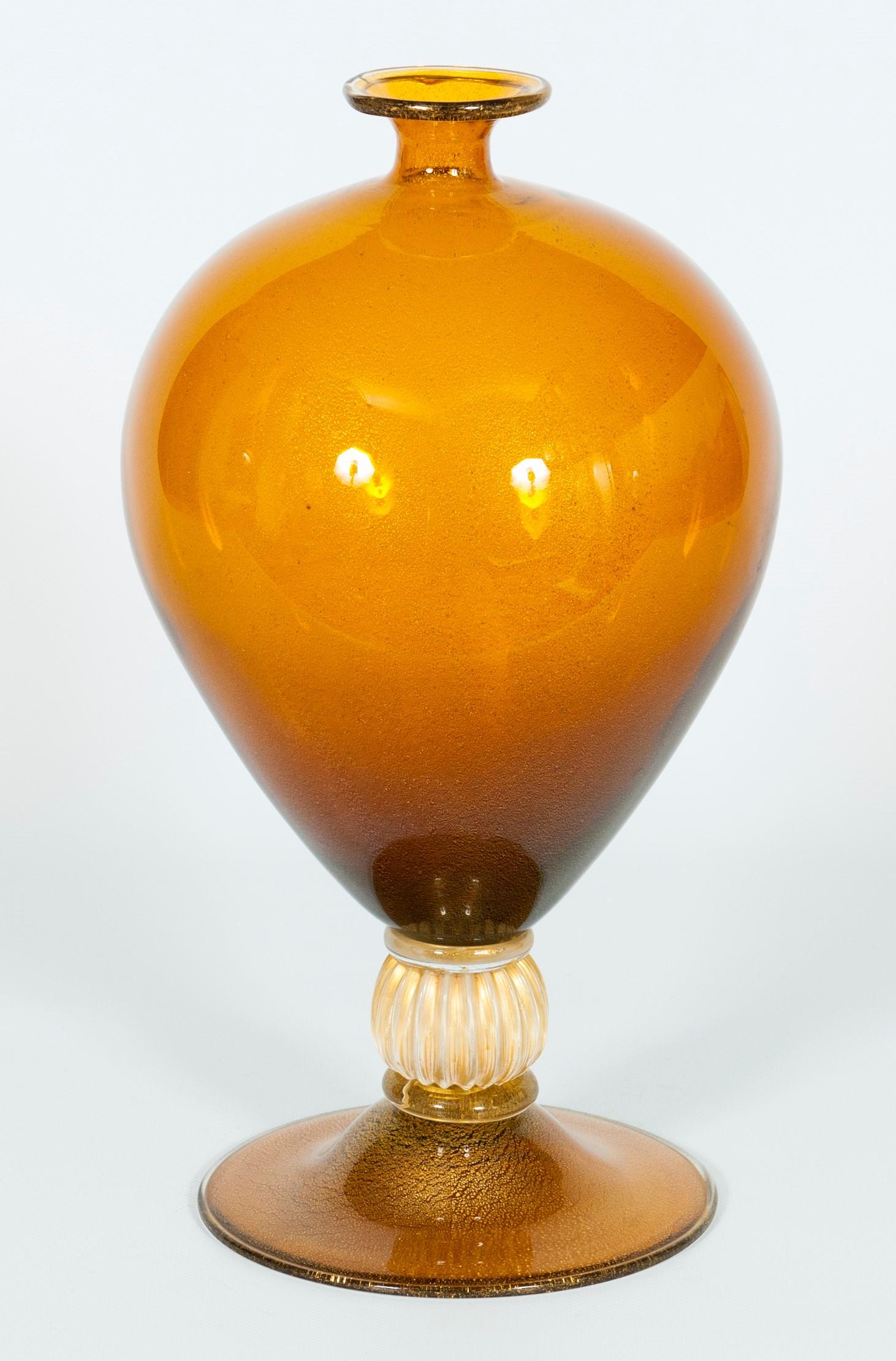 Iconic Italian Murano Glass “Veronese” Vase Amber with 24-karat Gold, 1980s.
This iconic “Veronese” vase is a classic from the Murano glassblowing tradition. Its rounded and spherical shapes are pure elegance.
The base and the main upper part are