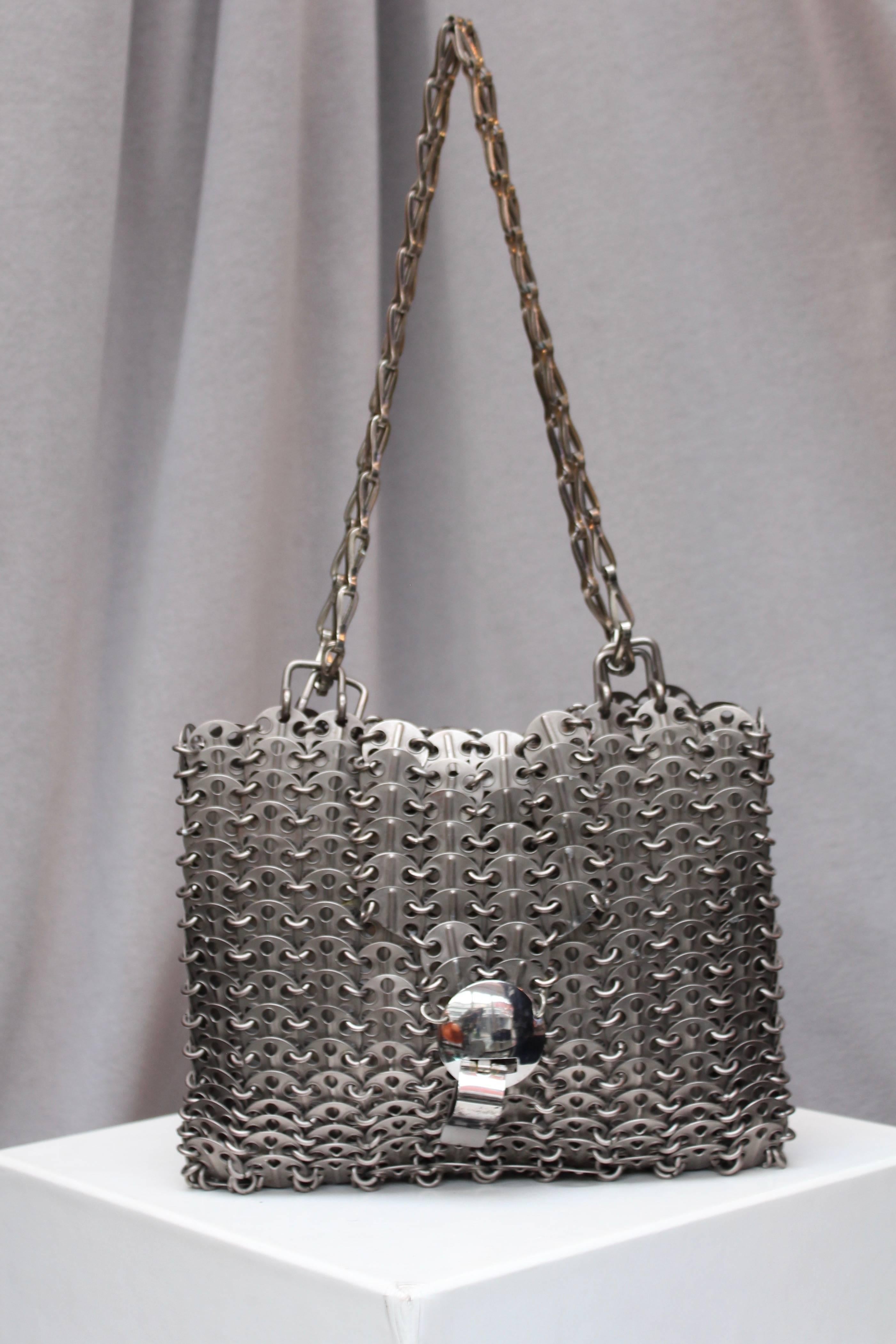 PACO RABANNE (Made in France) Iconic “69” bag comprised of silver-tone perforated chips, typical of the fashion house work in the 1960-1970’s. This piece features a flap and is decorated with a cylindrical closure issued in limited numbers at the