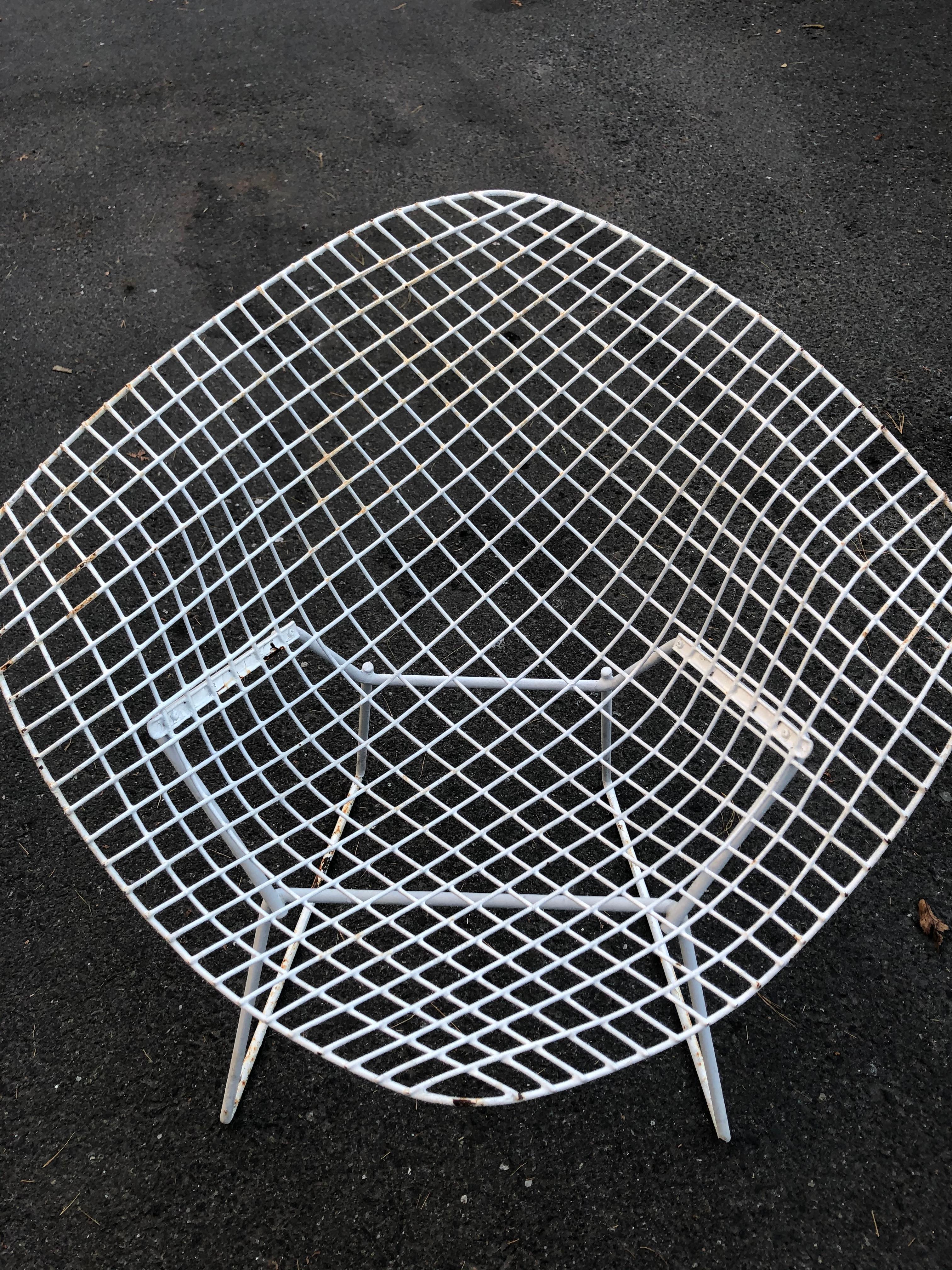 Pair of vintage Mid-Century Modern Harry Bertoia for Knoll welded steel wire diamond chairs that are painted white. Great bones but some age appropriate wear and priced accordingly.