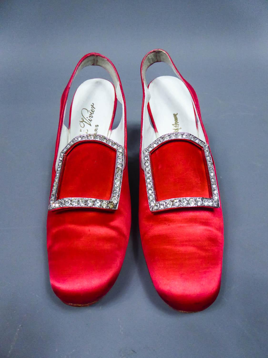 Circa 1970
France for the American market

Iconique Pair of Roger Vivier pumps for the American luxury market from the 70s. Fully covered with vermilion red silk satin and lined with white leather. Rounded ends decorated with a silver buckle covered