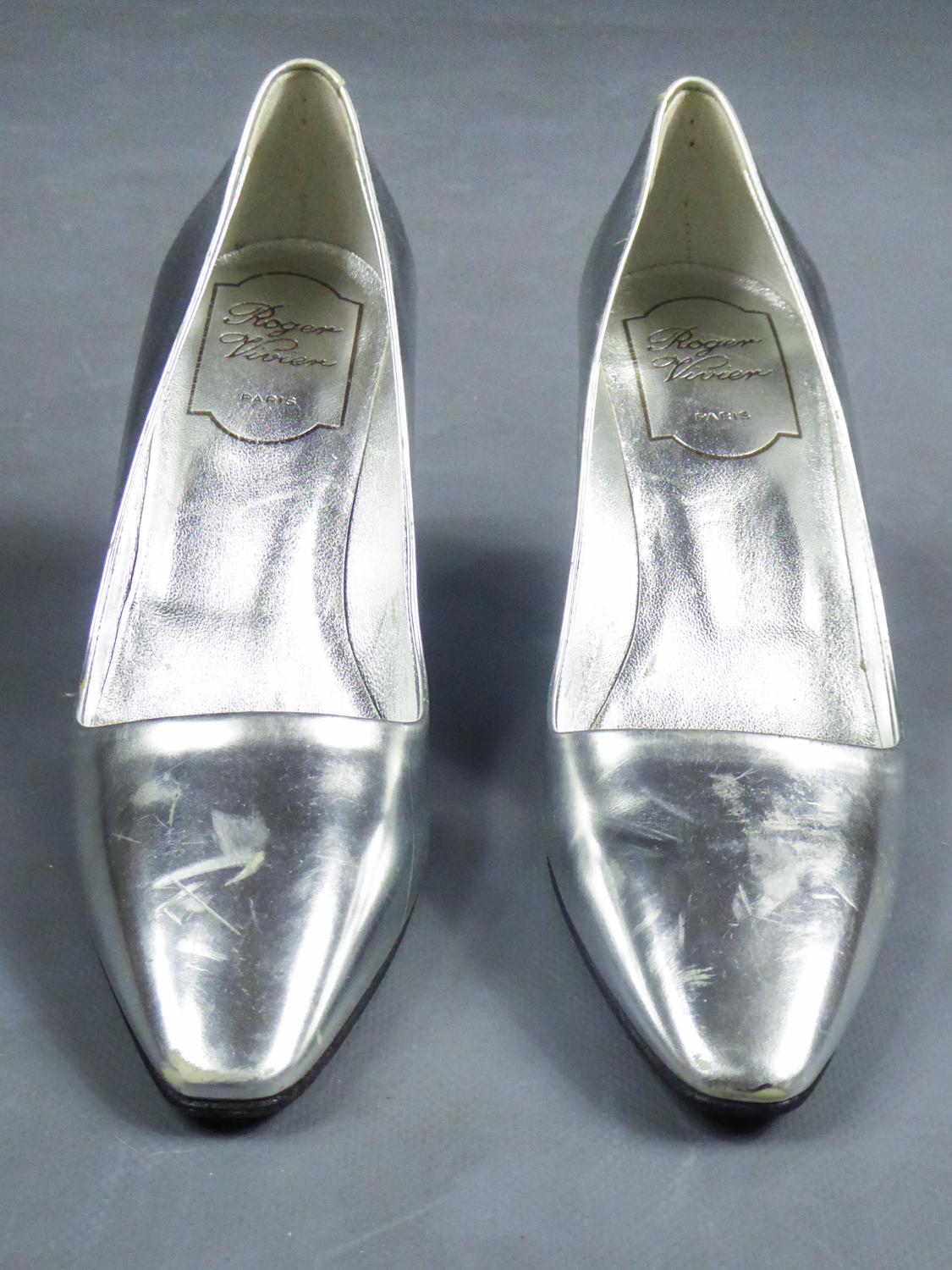 Circa 1980/1990
France/Italy

Iconic Pair of collector's pumps with Virgule heel by Roger Vivier dating from the 1980s. Silver and waxed leather with metallic comma heel and Roger Vivier Paris logo on the sole. Some easily polishable scratches on