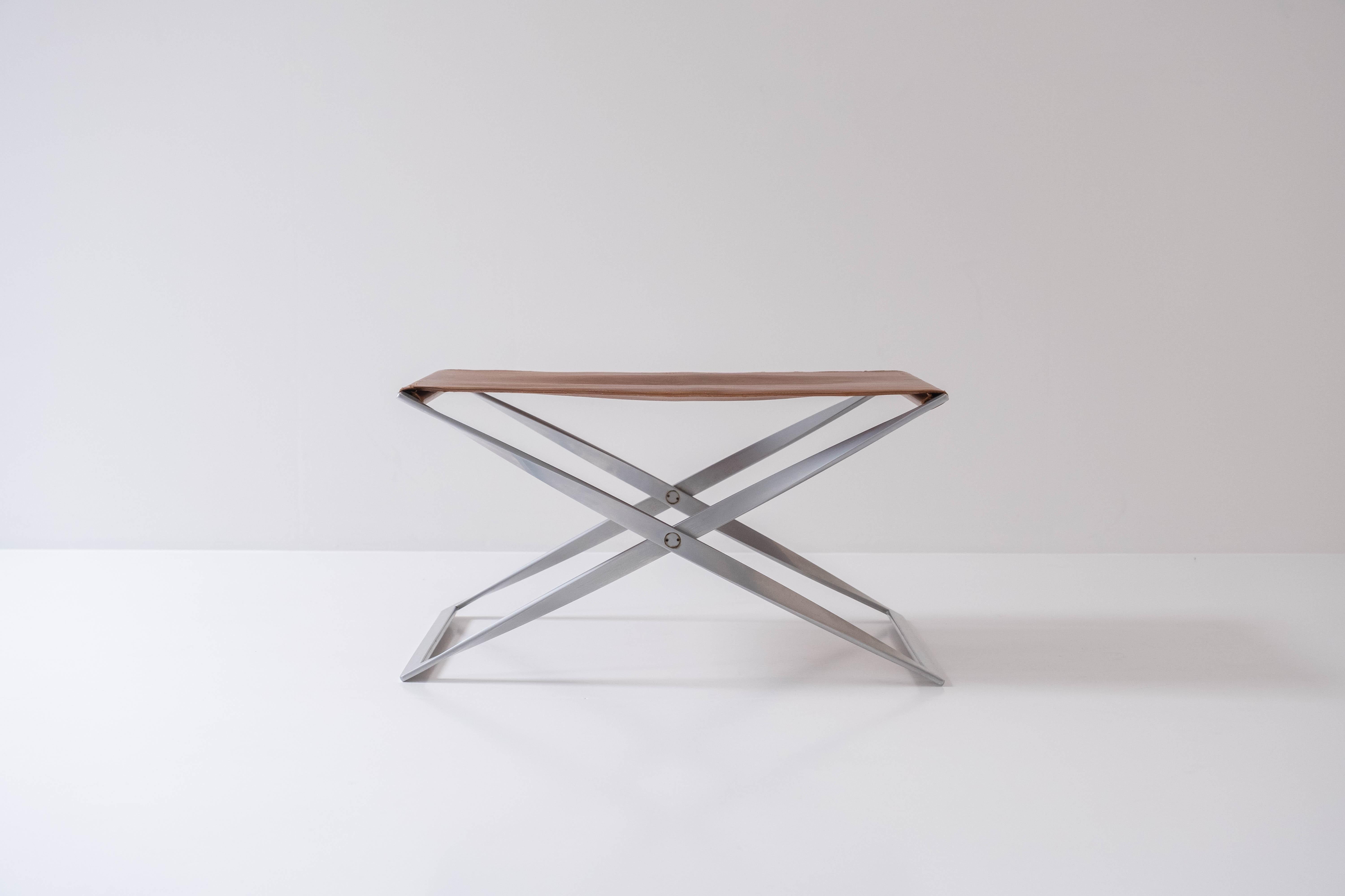 Iconic PK 91 folding stool designed by Poul Kjærholm and manufactured by E. Kold Christensen, Denmark 1961. This stool is from an early production and has a matt chromed plated steel frame with its original leather seat. It does not have the EKC