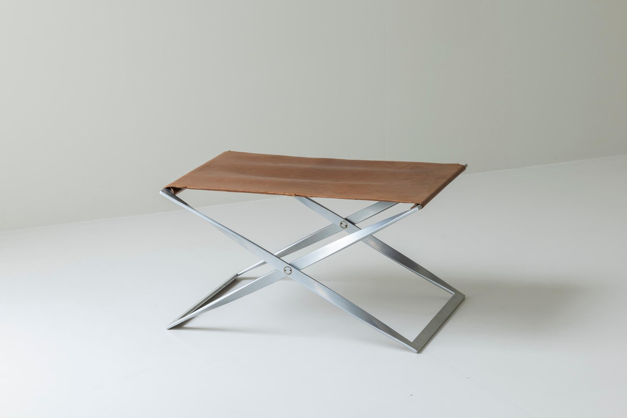 Iconic PK 91 folding stool designed by Poul Kjærholm and manufactured by E. Kold Christensen, Denmark 1961. This stool is from an early production and has a matt chromed plated steel frame with its original leather seat. It does not have the EKC