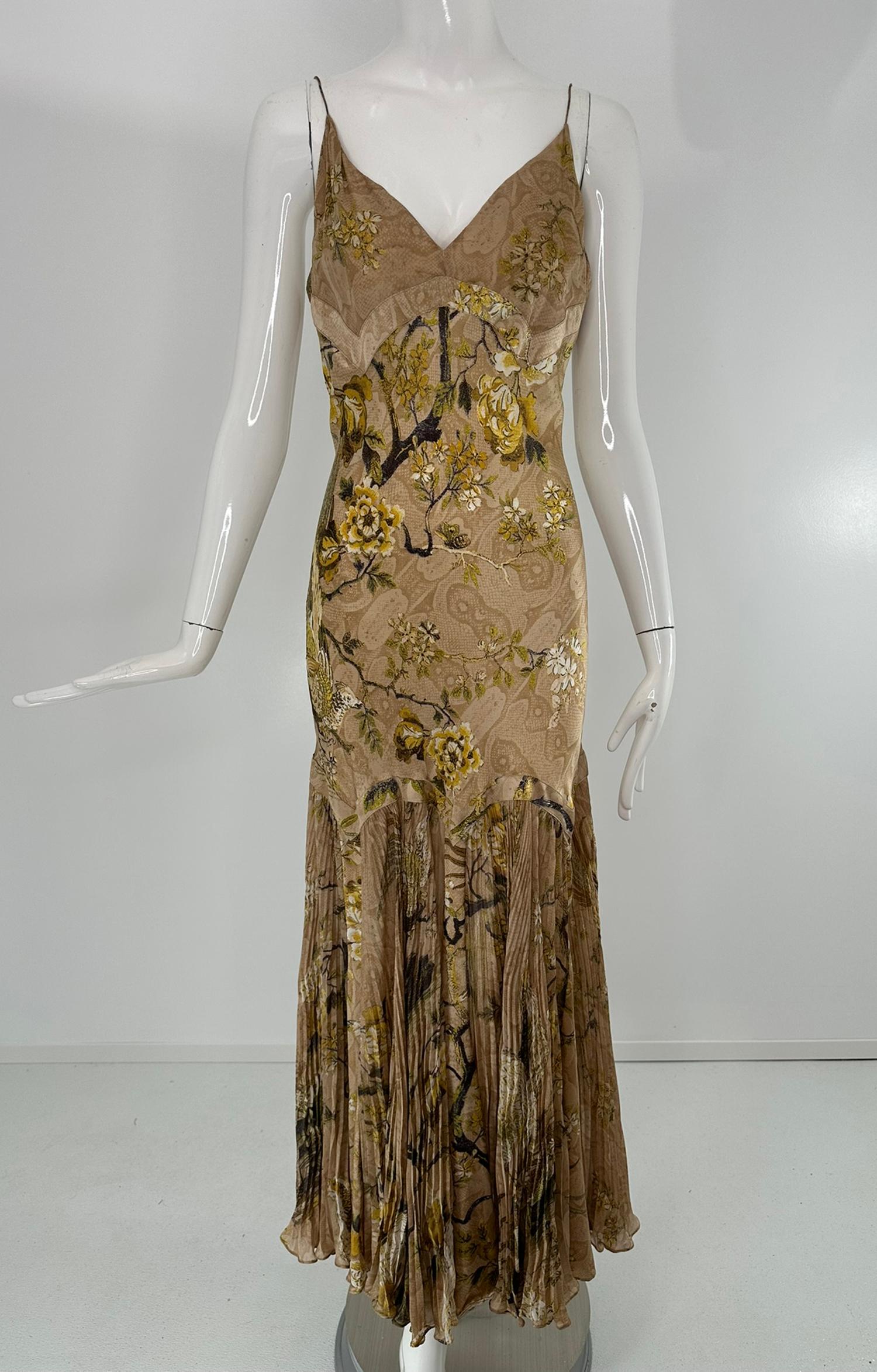 Iconico Roberto Cavalli A/I 2006 con stampa in seta dorata e disegno asiatico stencil in metallo dorato, firmato sulla stampa. L'abito con scollo a V, cinturino a spaghetti e taglio sbieco è aderente sul busto e sui fianchi; una fascia separa il