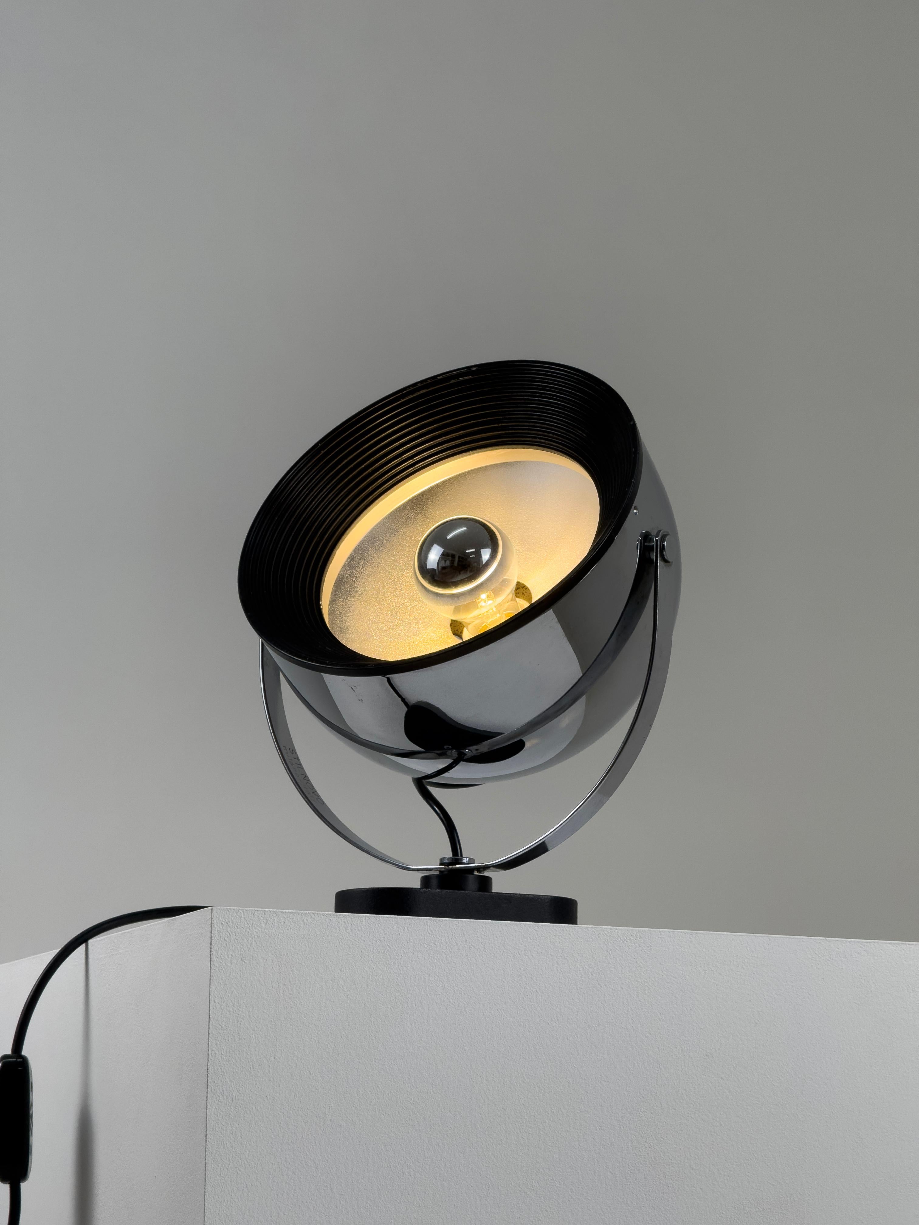 This striking adjustable spotlight lamp, presented here in its largest variant, is crafted entirely from chrome steel. Designed by Gae Aulenti and Livio Castiglioni for Stilnovo in 1972, it exemplifies the bold creativity and industrial elegance of