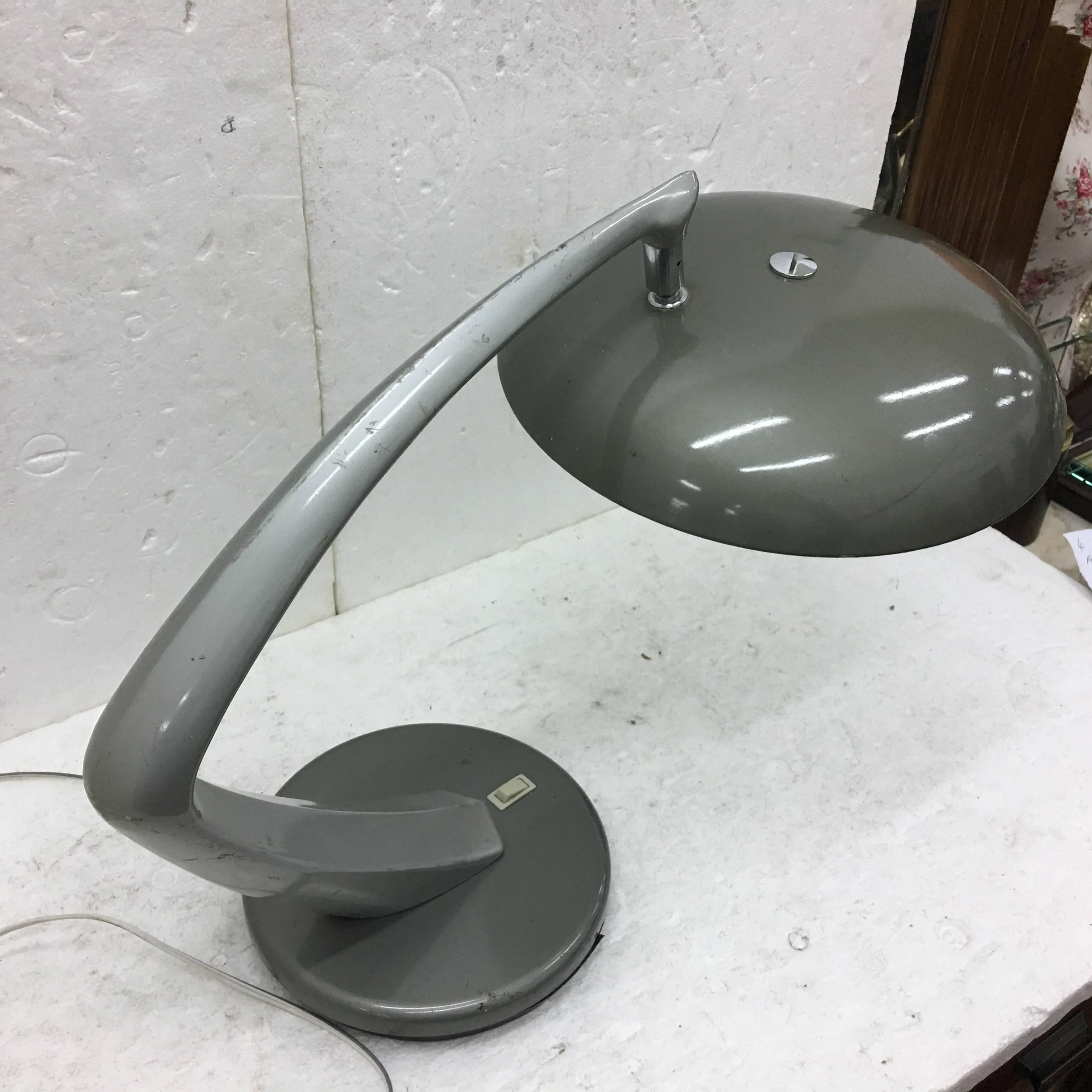 This is a turnable table lamp named Boomerang by the famous Spanish factory Fase, grey metal and glass. It works with both 110 and 220 Volt and need regular e14 bulbs.