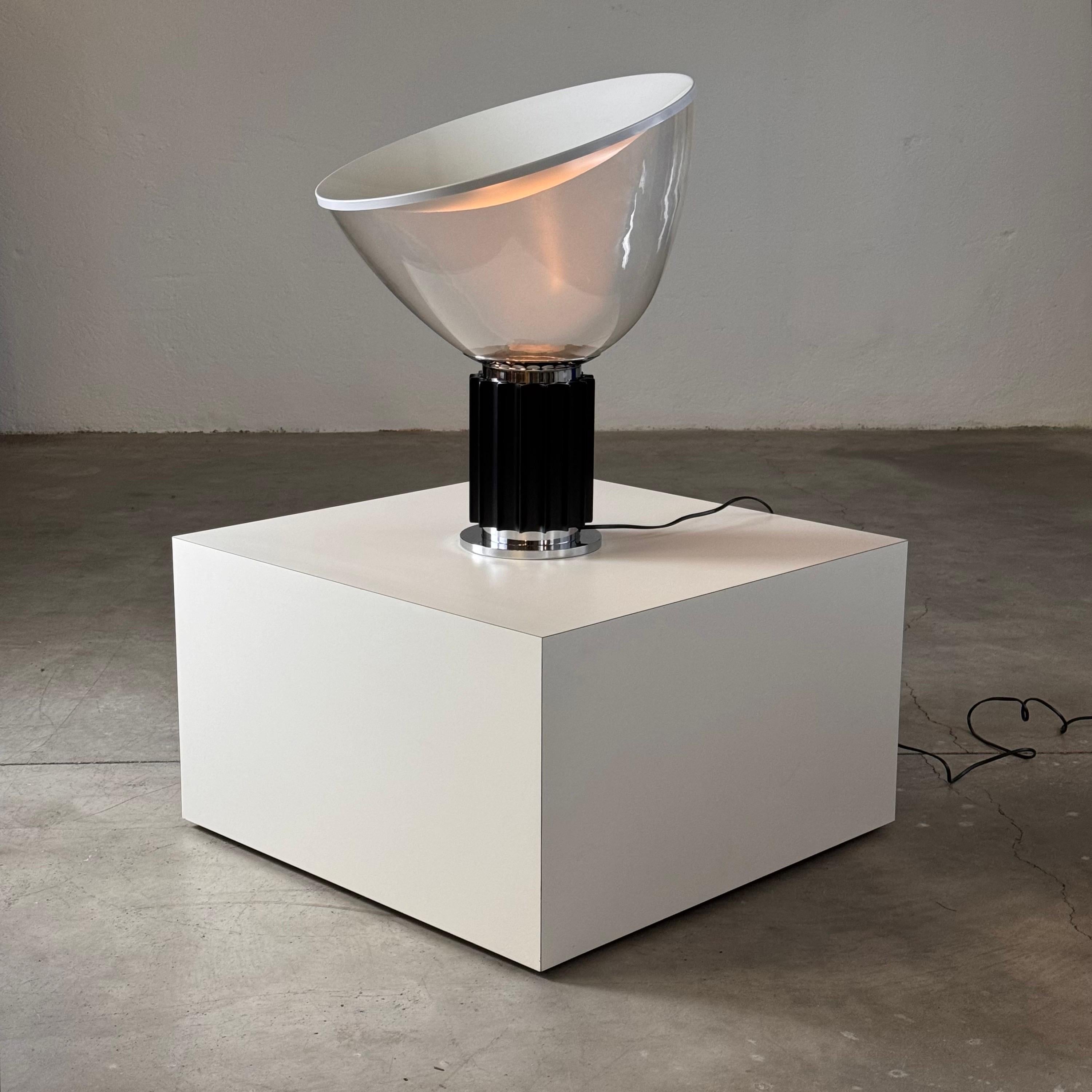 An iconic piece of Italian design, this Taccia table lamp by Achille and Pier Giacomo Castiglioni for Flos is from an untouched 1980s stock. It has been gently displayed only in a showroom window for a short period, preserving its pristine condition