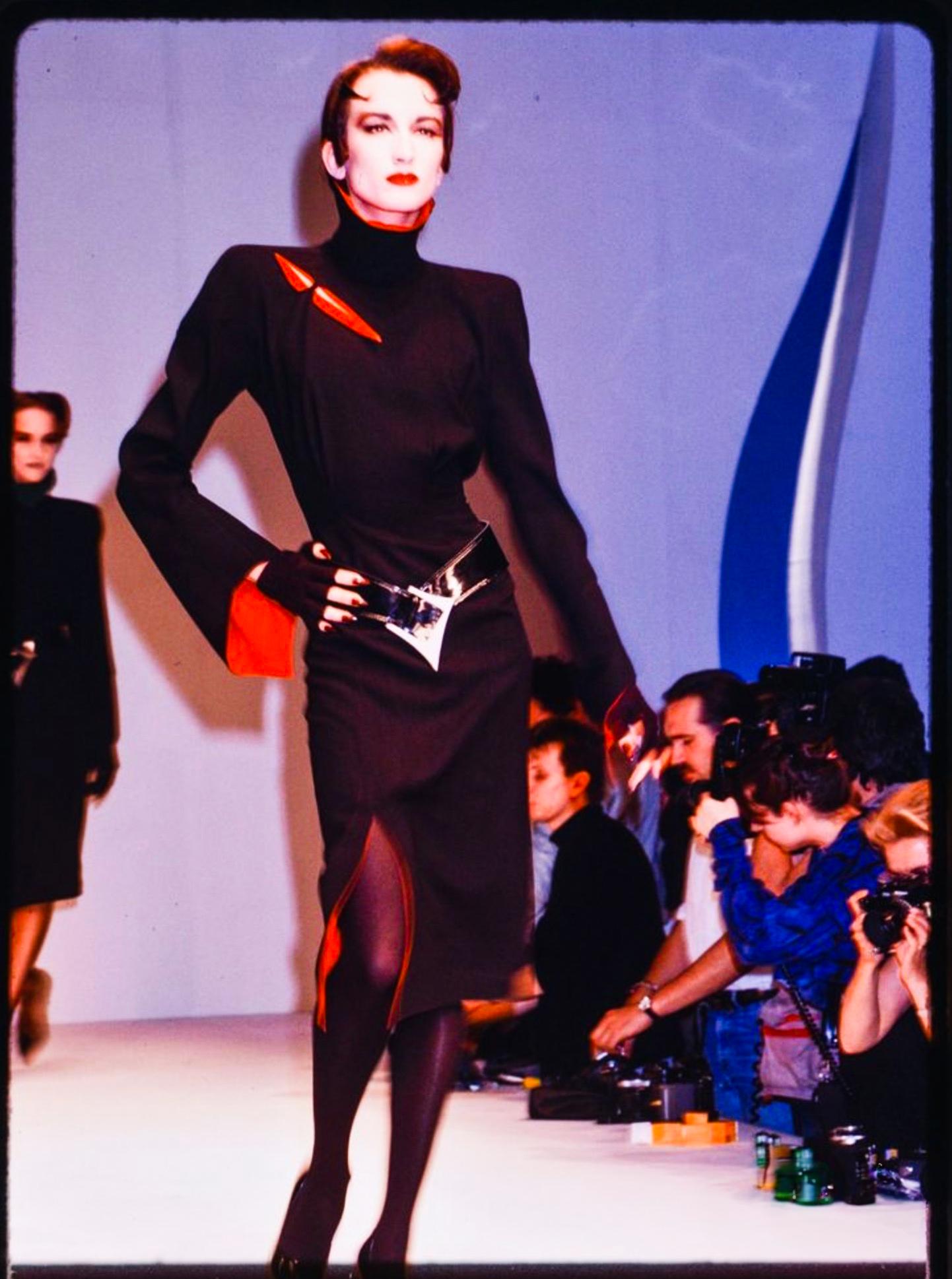 In Thierry Mugler’s spectacular “Les Infernales - SHE DEVILS” Collection FW 1988/89, the designer’s flair for drama reaches a smoldering crescendo in this black-and-red masterpiece. Striking the perfect balance between razor-sharp tailoring and